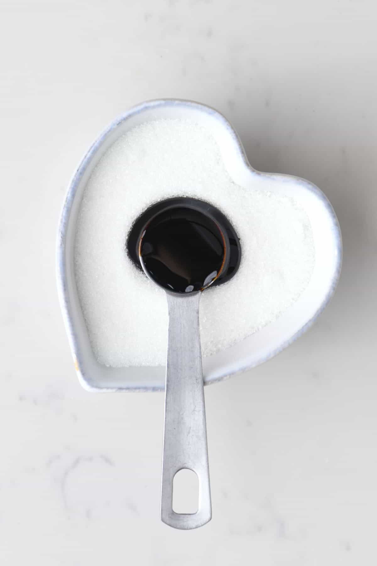 A bowl with white sugar and molasses