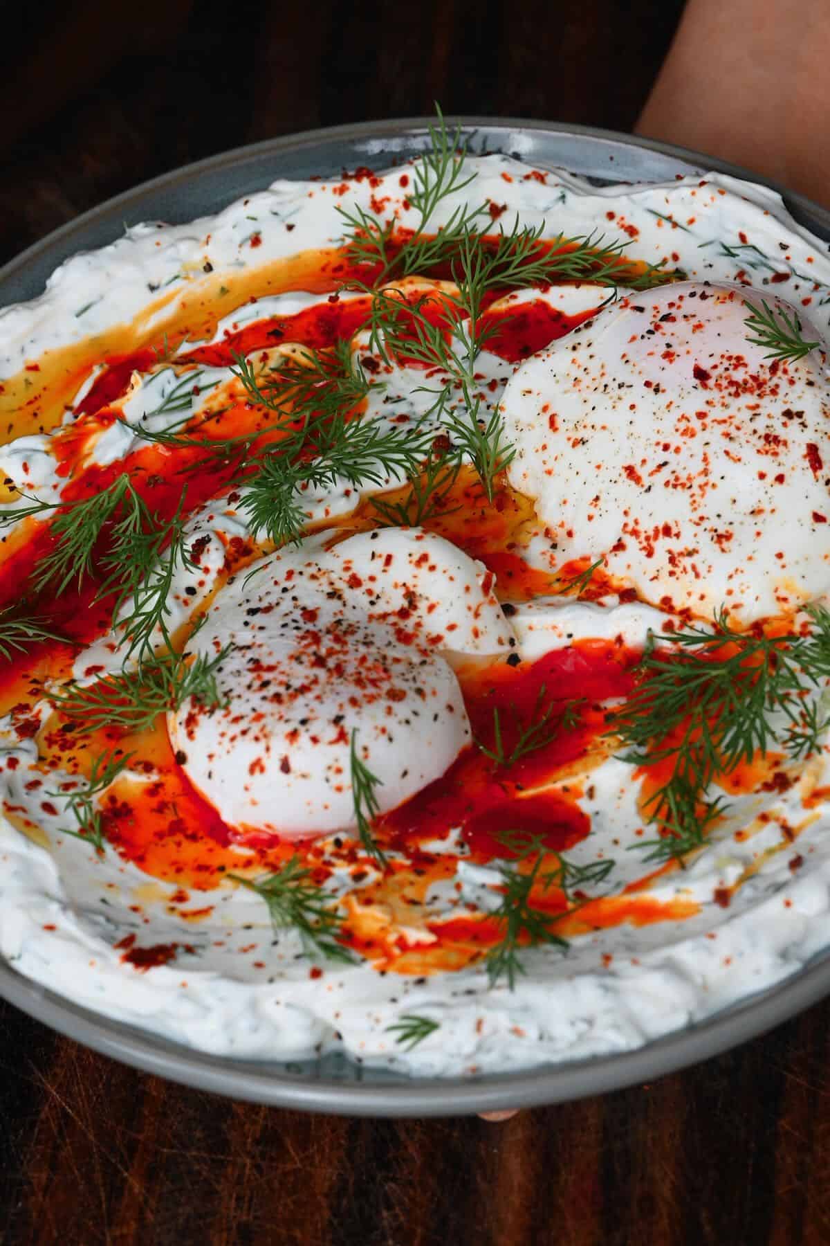 A plate with Turkish eggs topped with dill