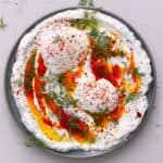 Turkish eggs topped with dill in a plate