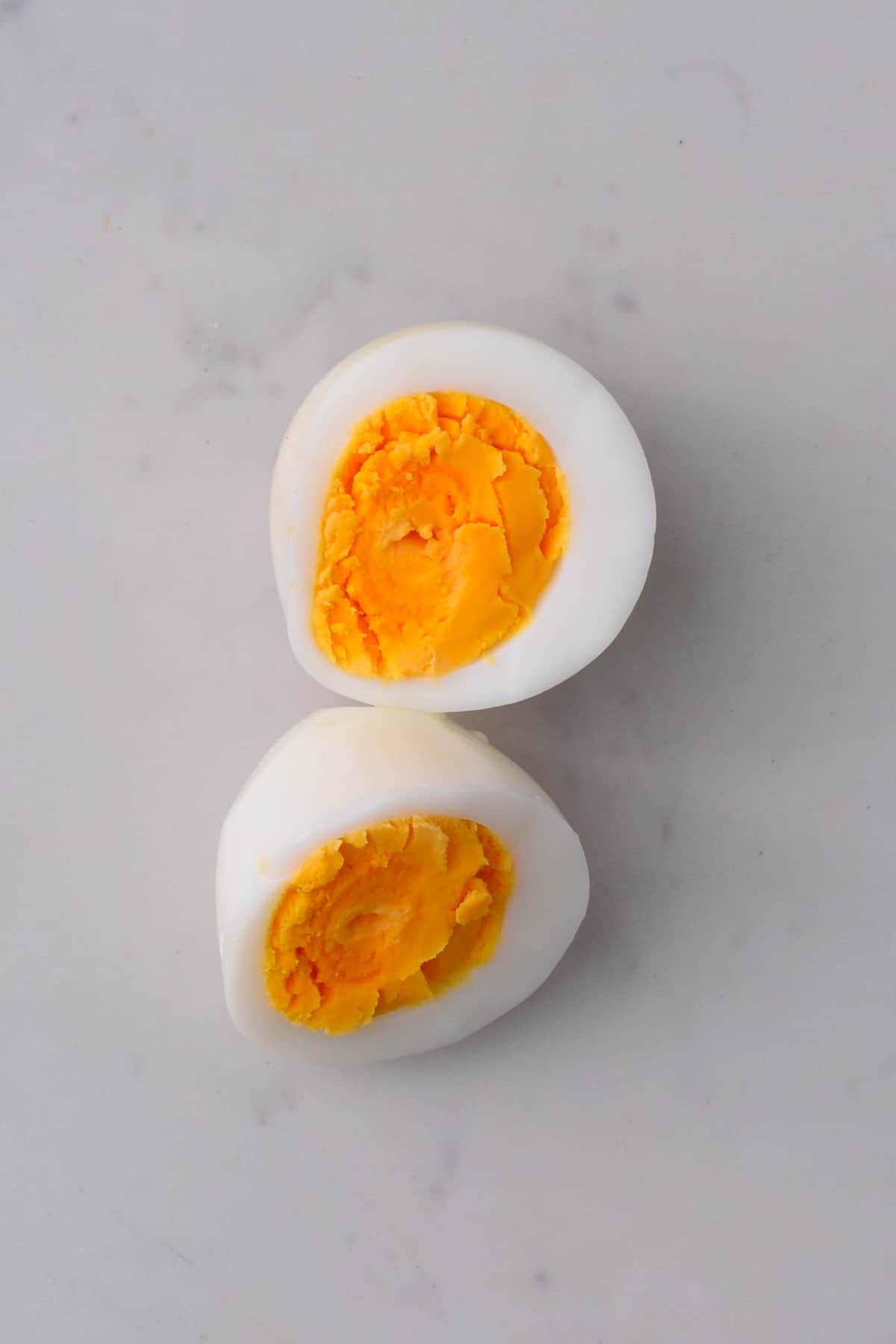 Cooked egg cut in half on a flat surface
