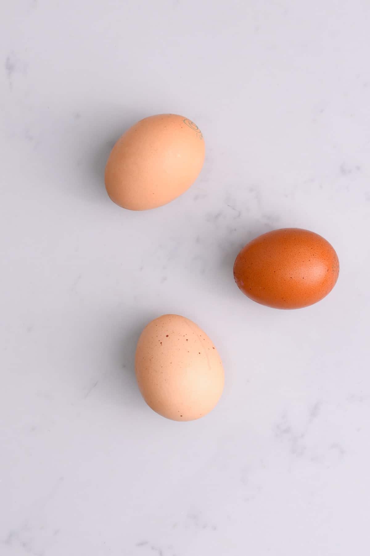 Three eggs on a flat surface