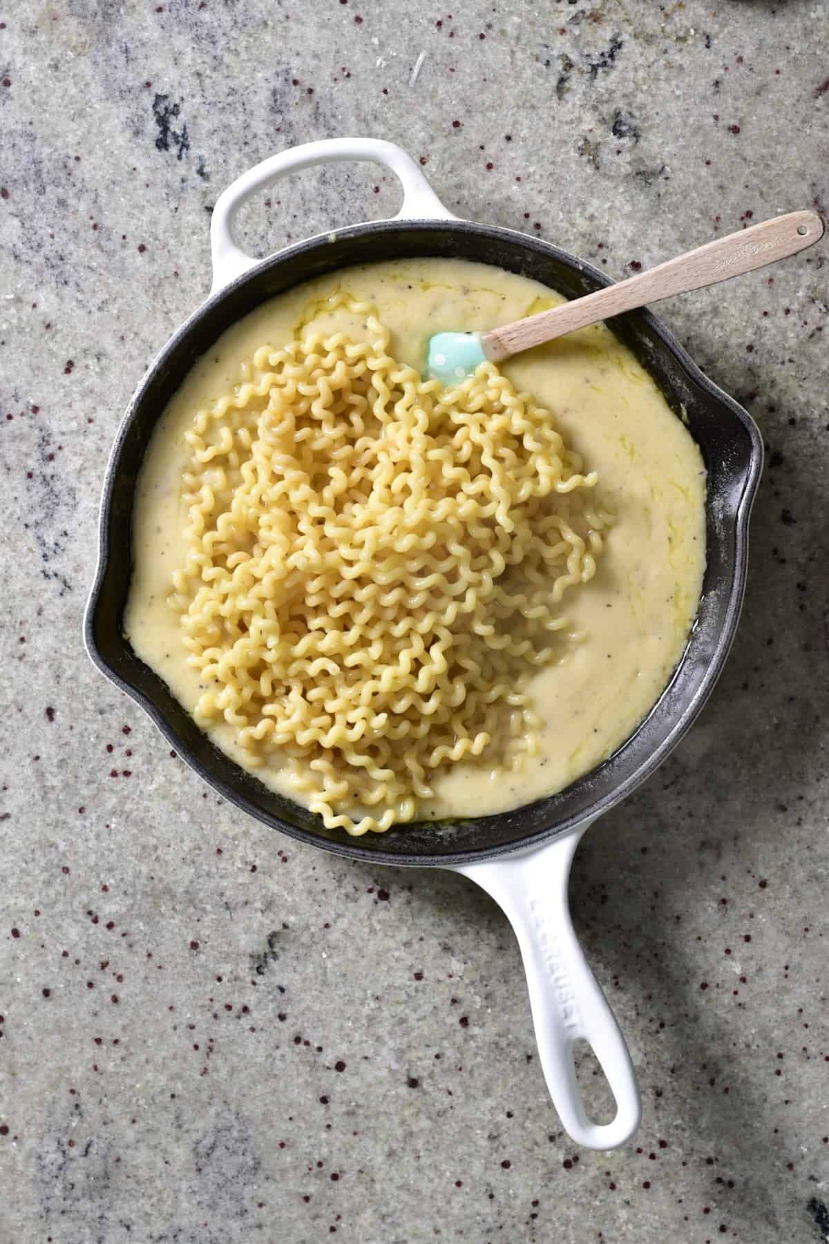 Mixing garlic cream sauce with pasta