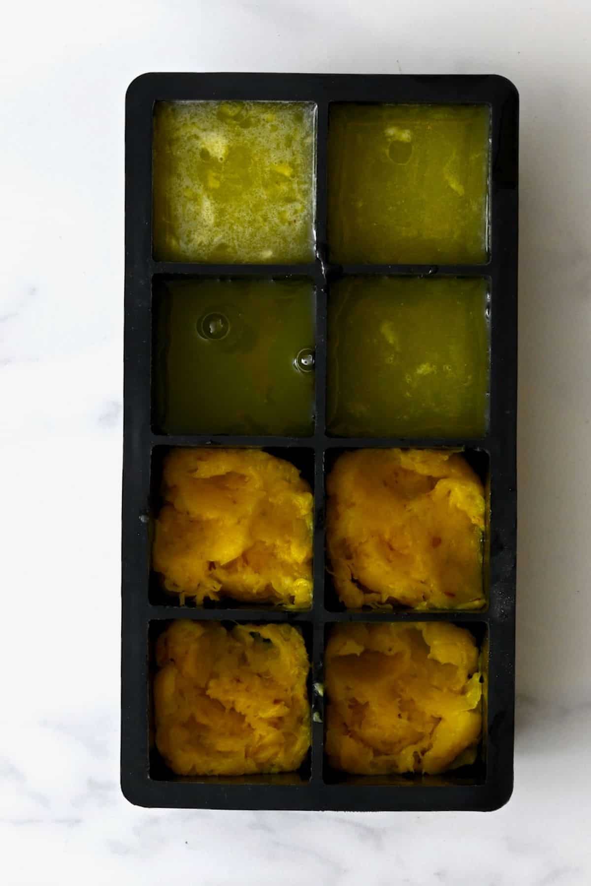 Ice cube tray with juice and pulp from pineapple