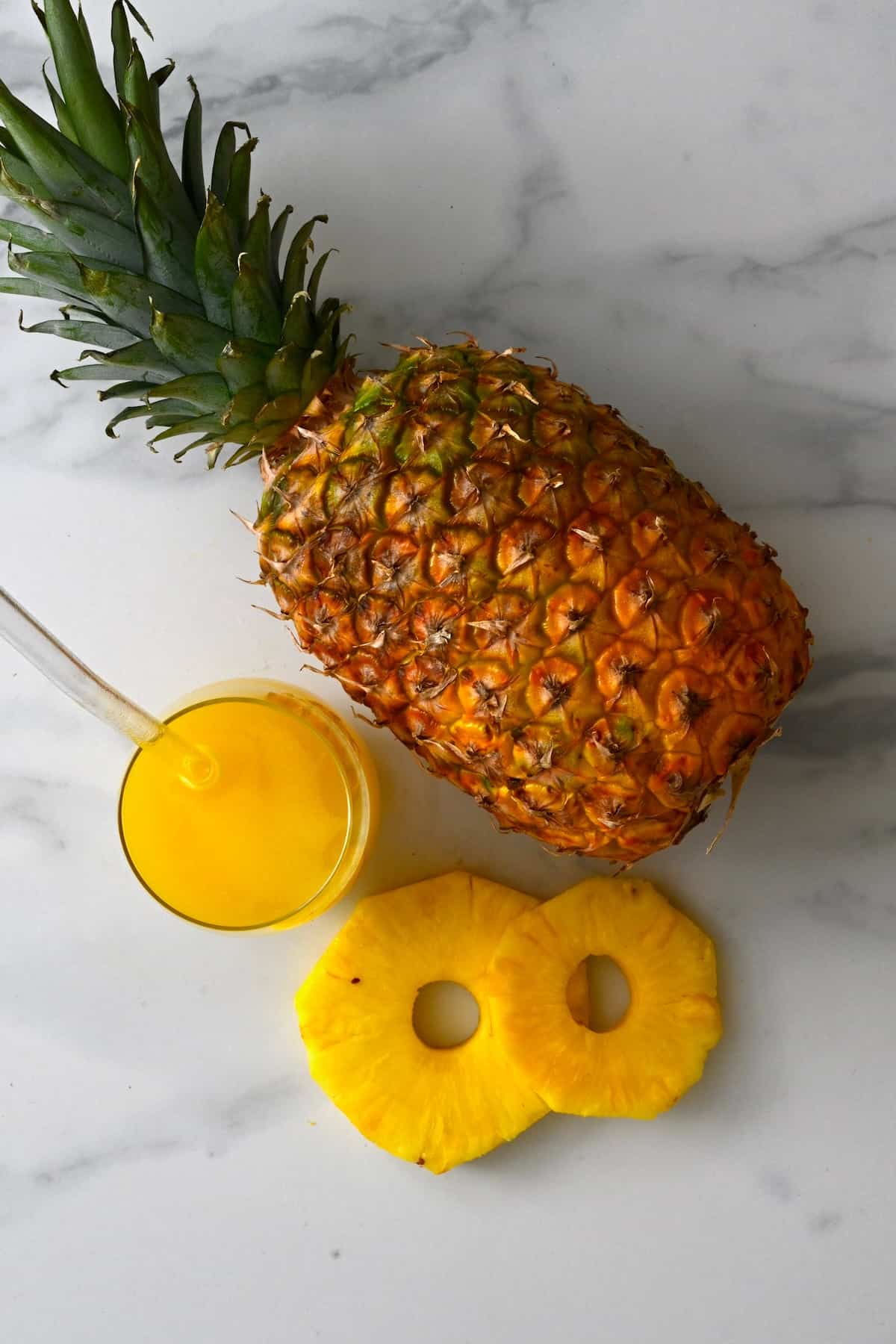 Pineapple and a glass with its juice next to it