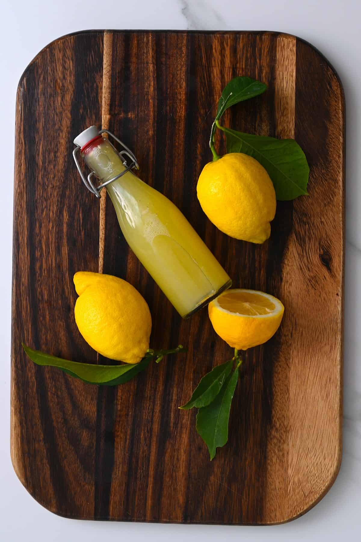 A small bottle with lemon juice and two and a half lemons