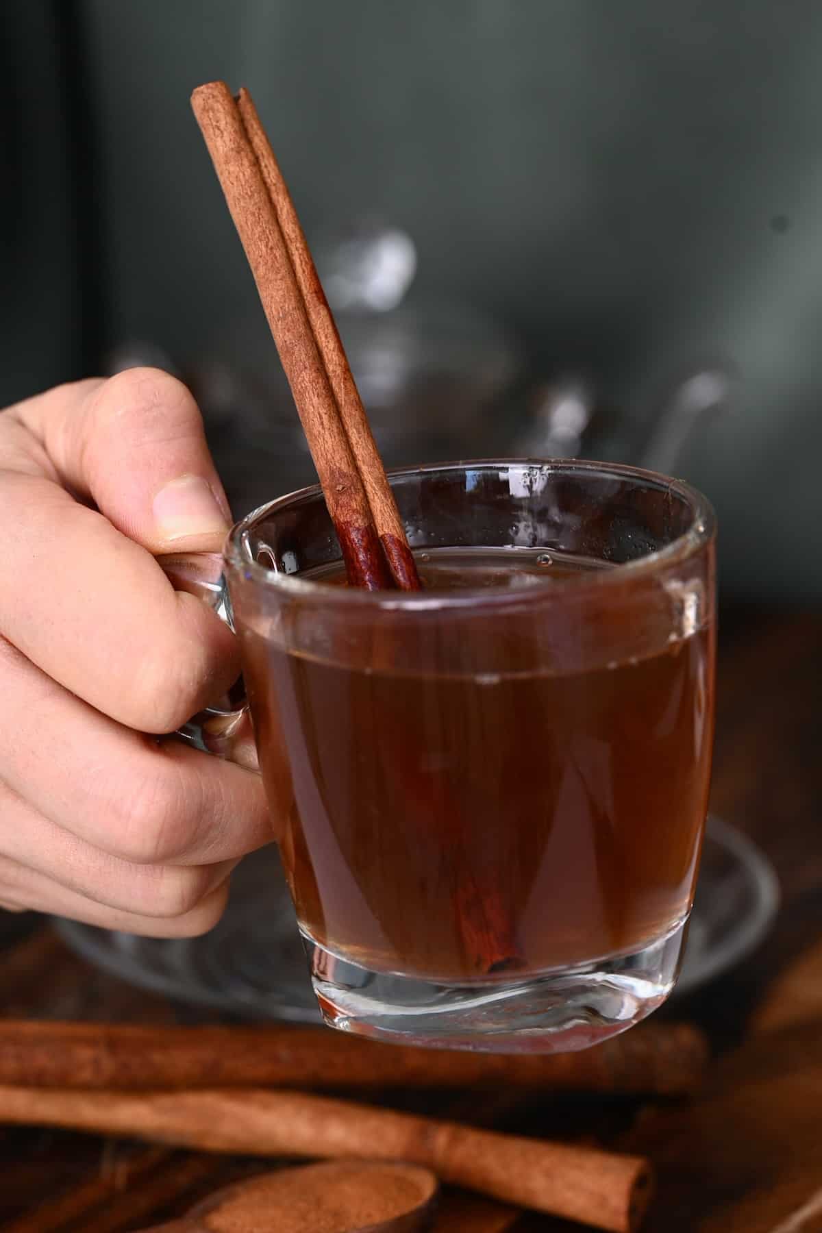A glass with tea and a cinnamon stick