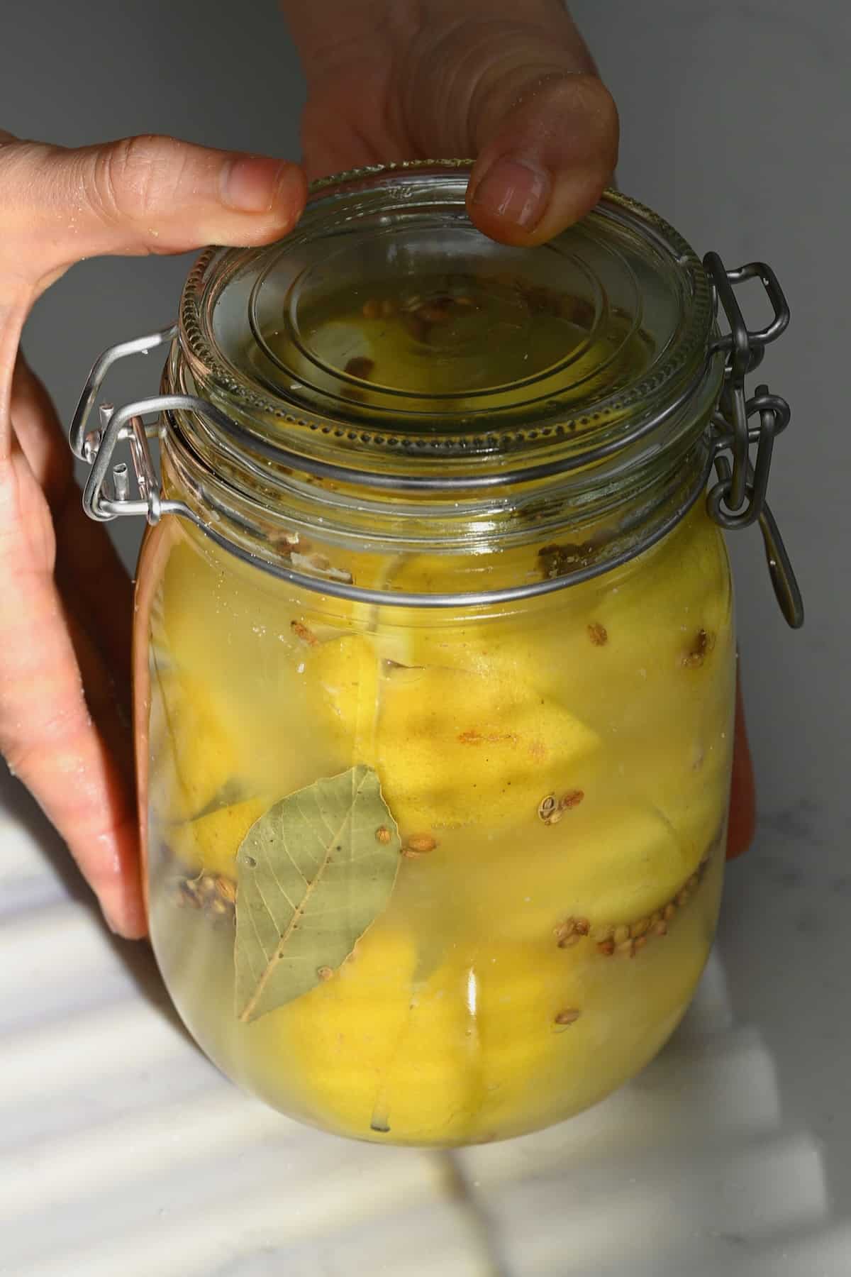 A jar with preserved lemons with coriander seeds