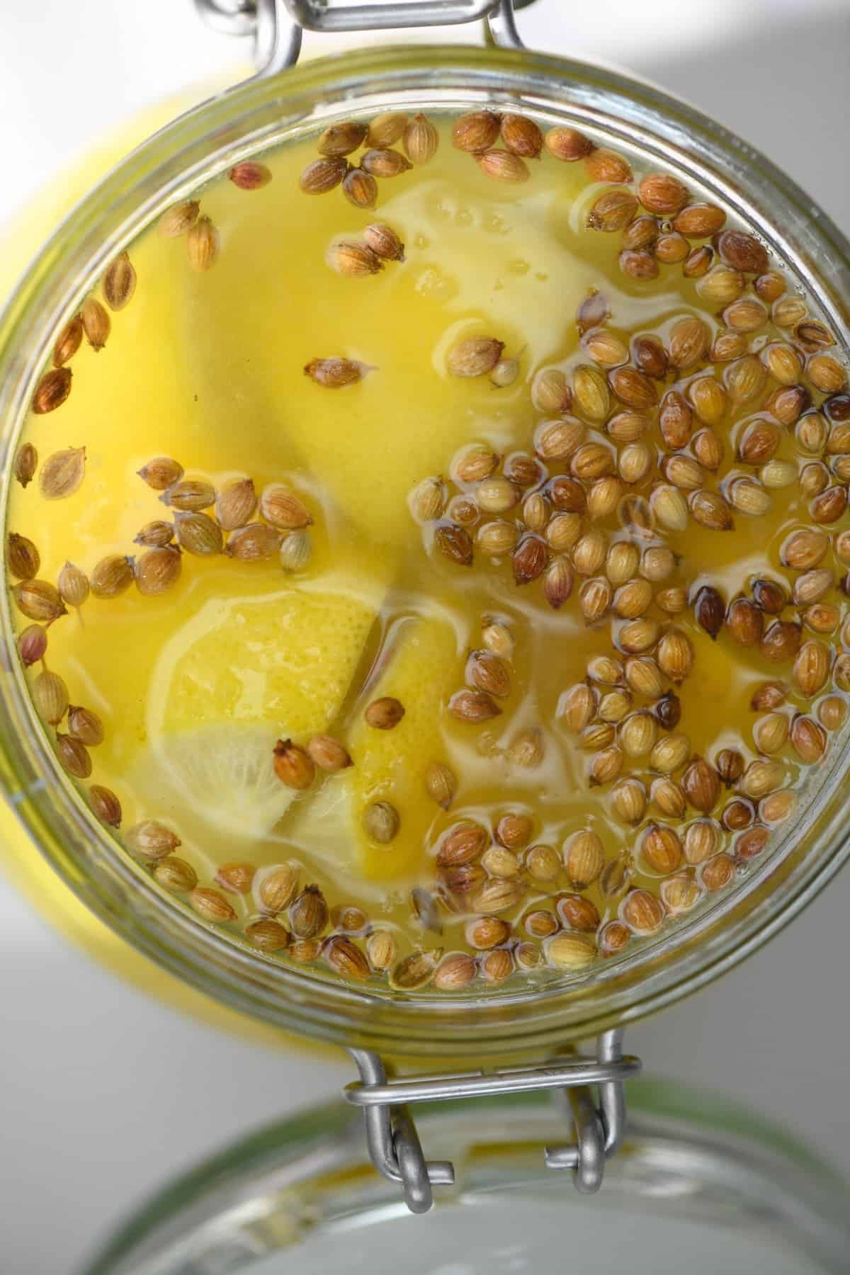 Top view of jar with preserved lemons with coriander seeds