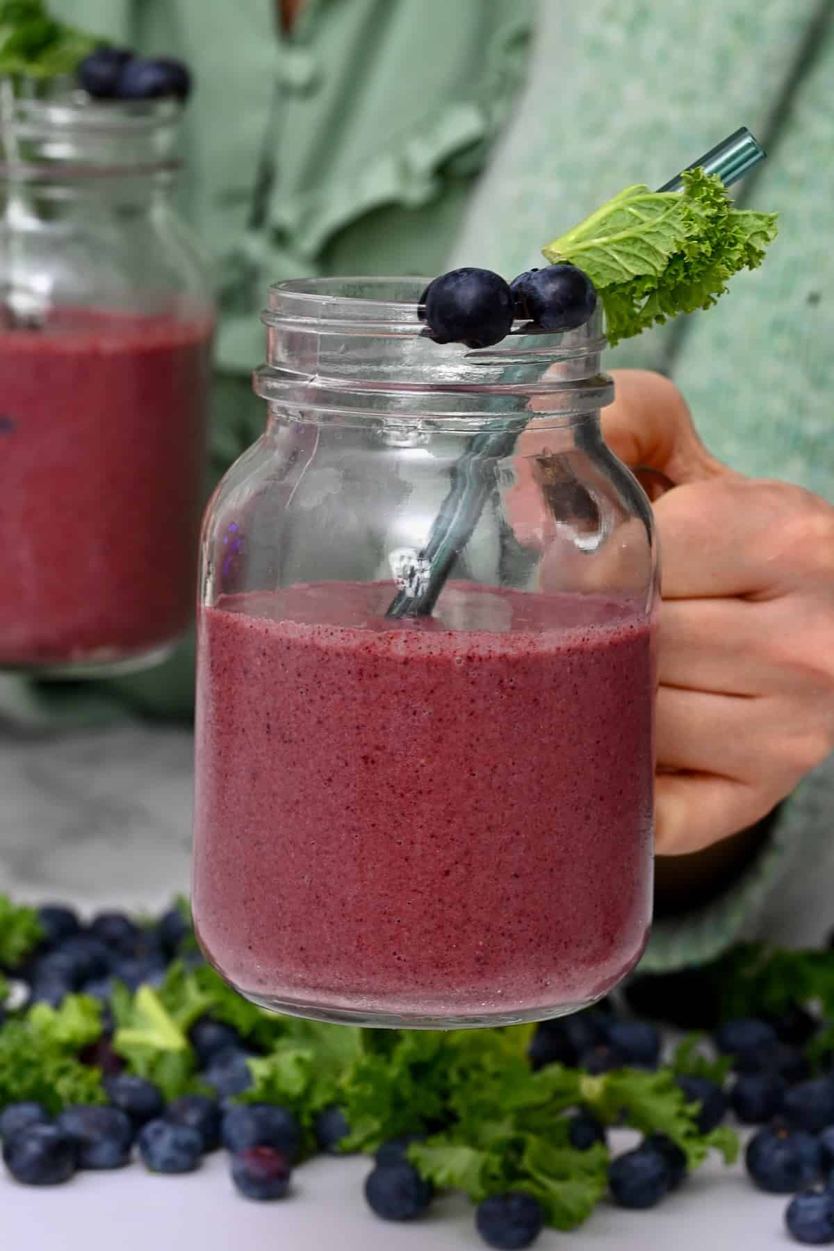 A mason jar with blueberry and kale smoothie