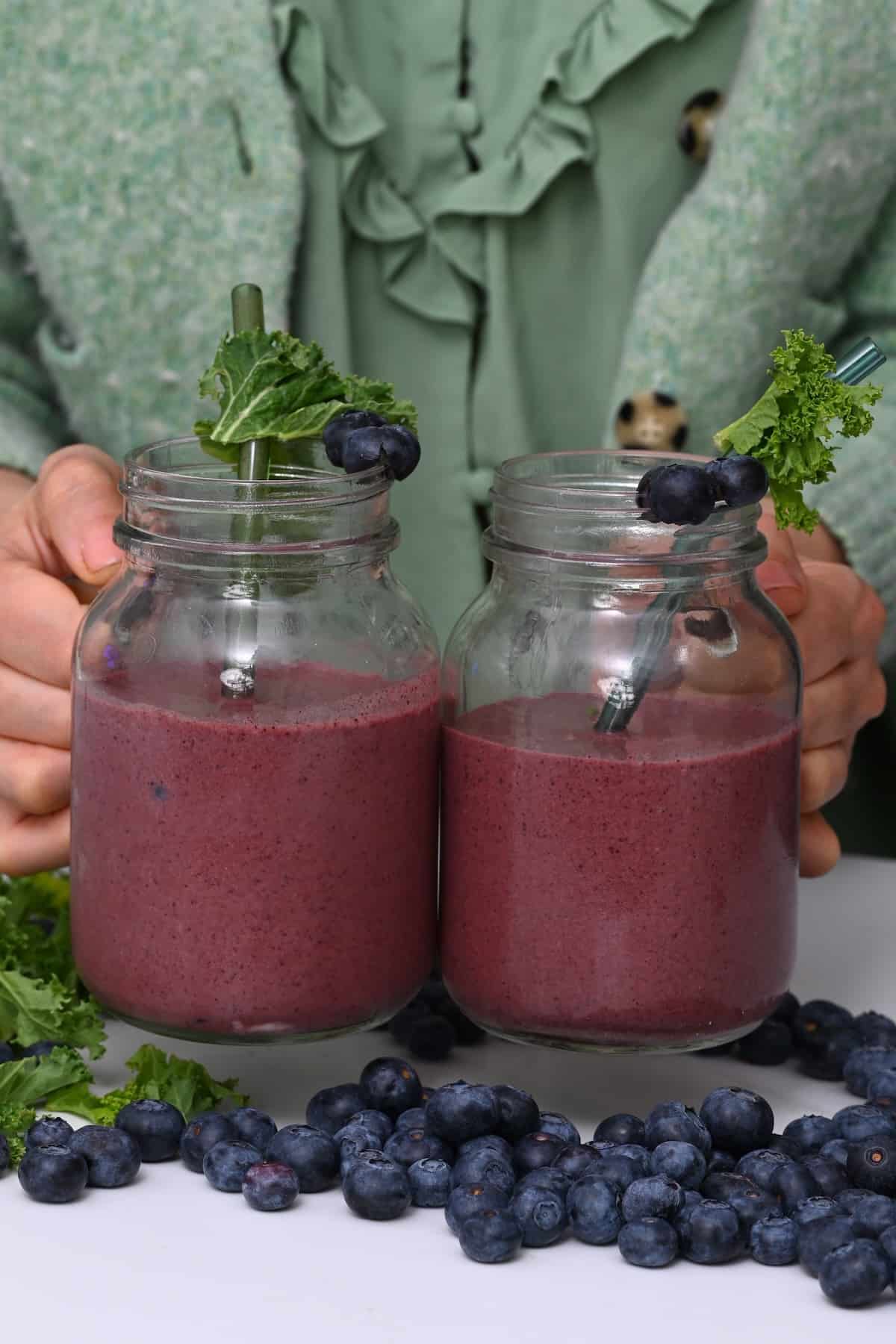 Two mason jars with blueberry kale smoothie