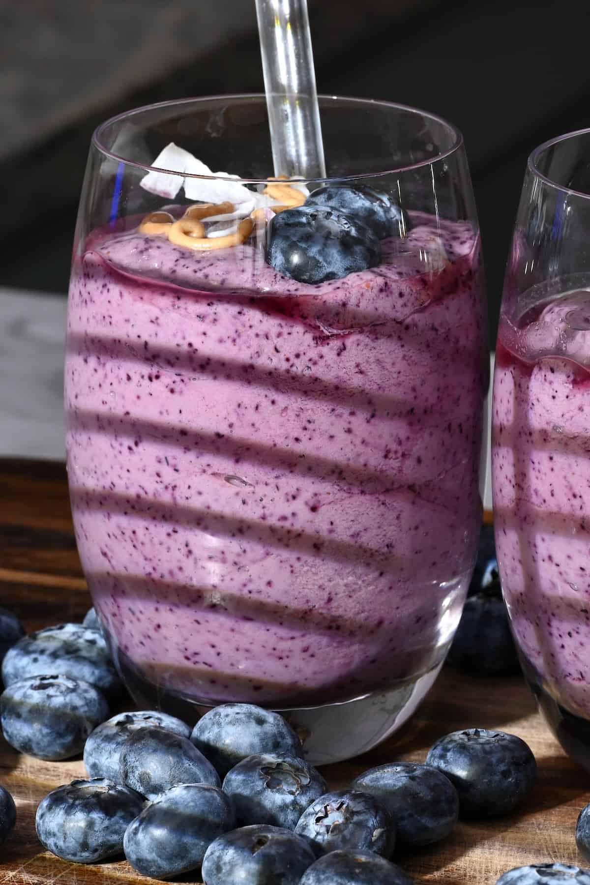 A glass with blueberry smoothie topped with blueberries