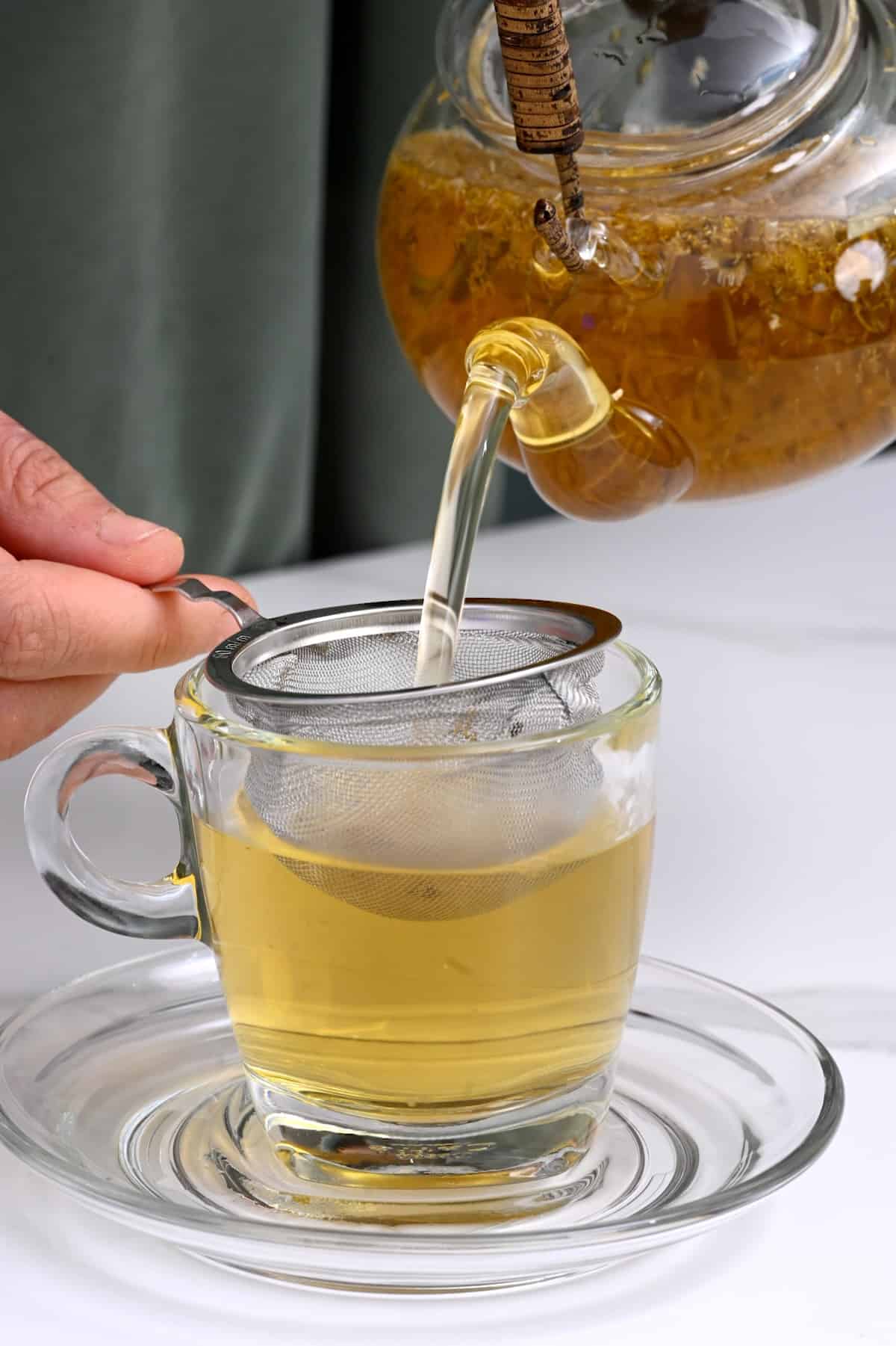 Pouring chamomile tea in a cup