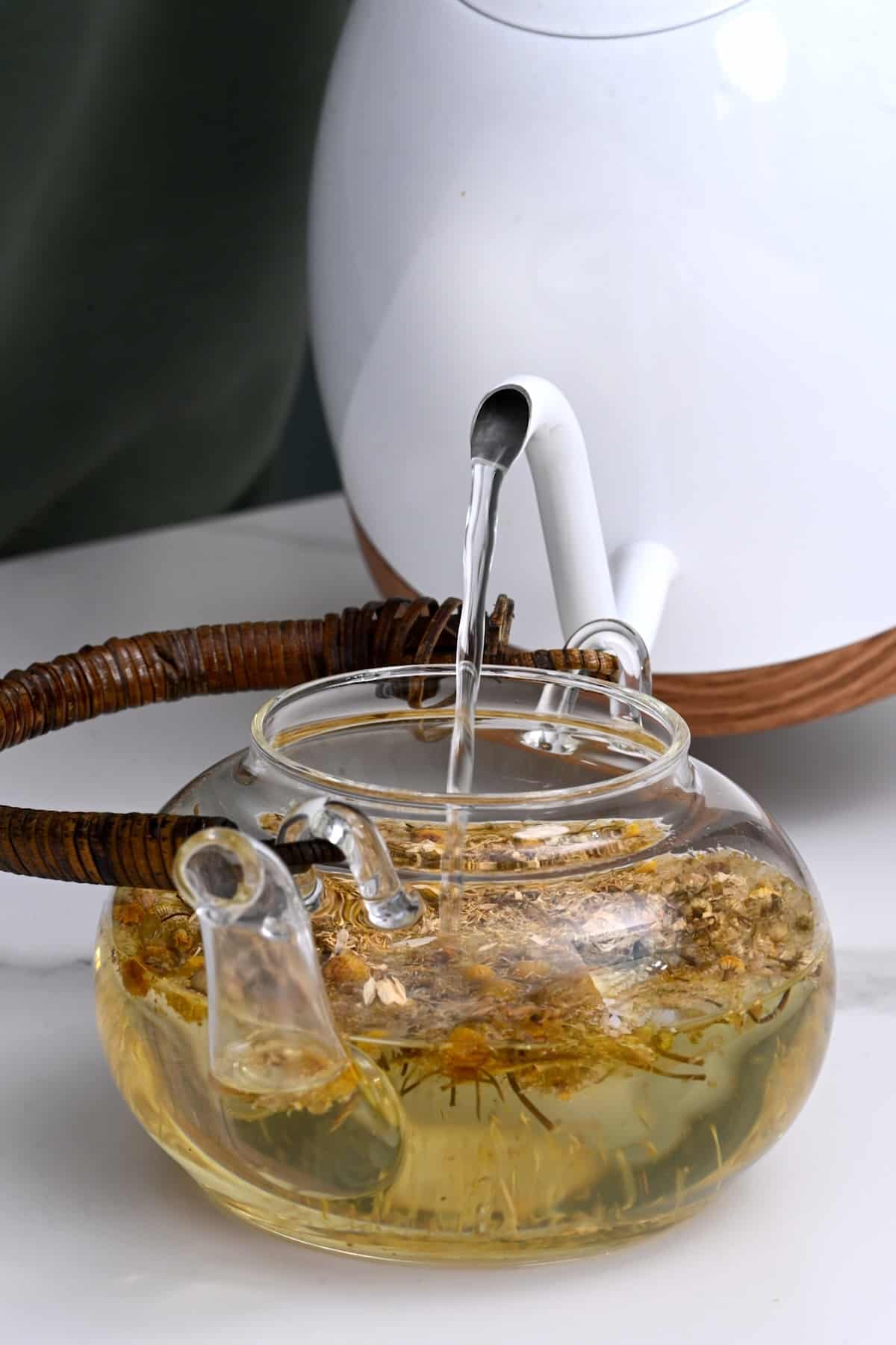 Pouring hot water over chamomile tea