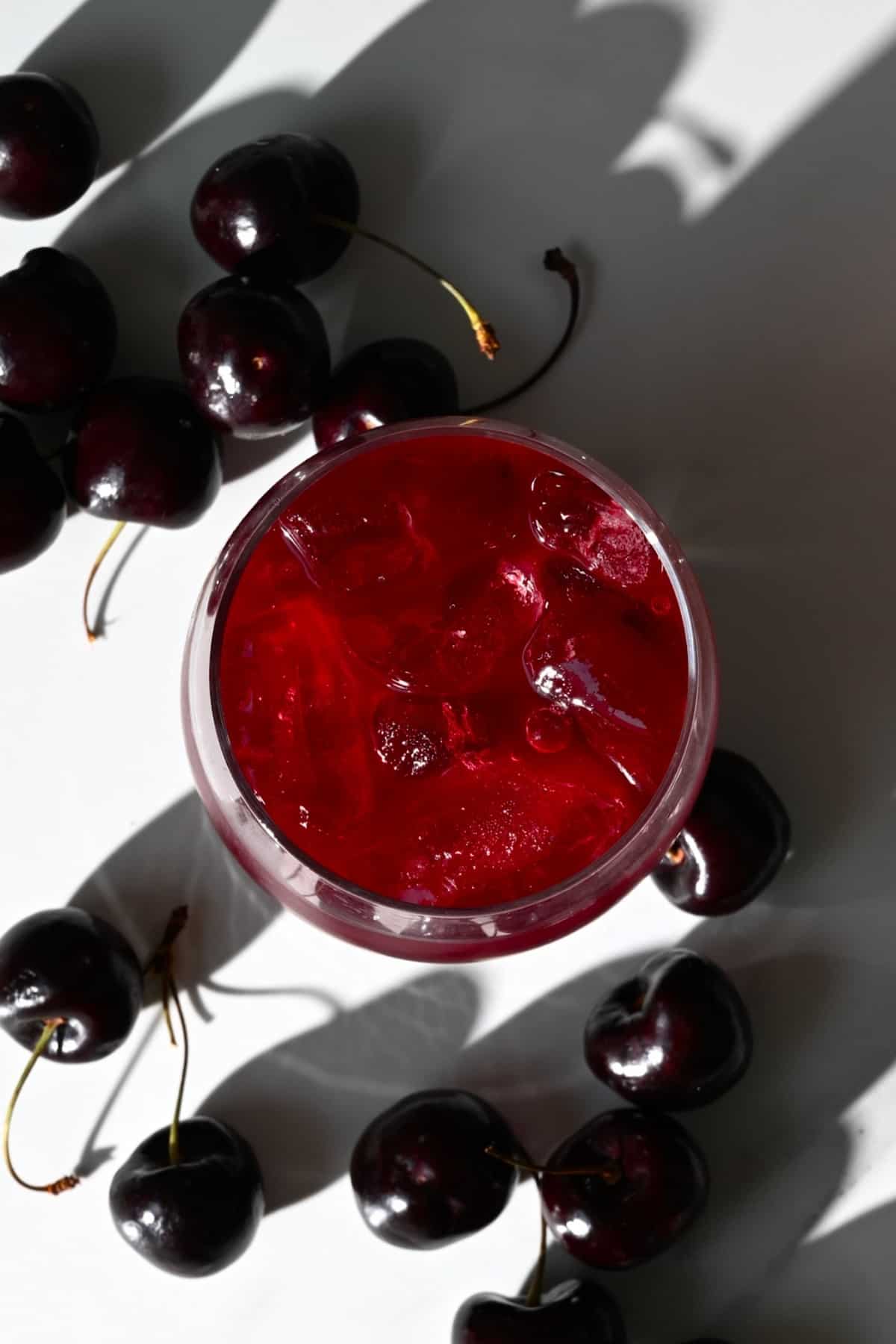 Top view of cherry juice in a glass with ice