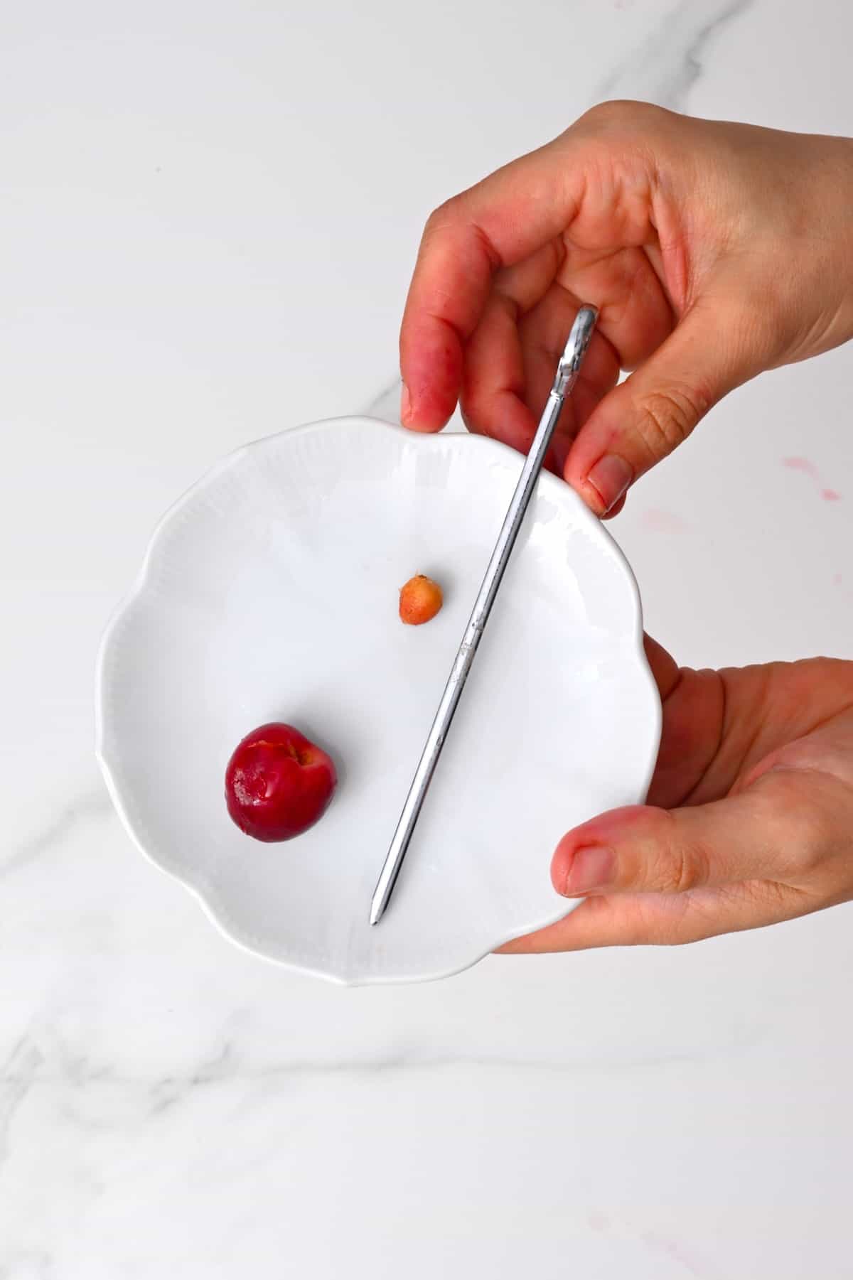 Using a skewer to remove a cherry pit