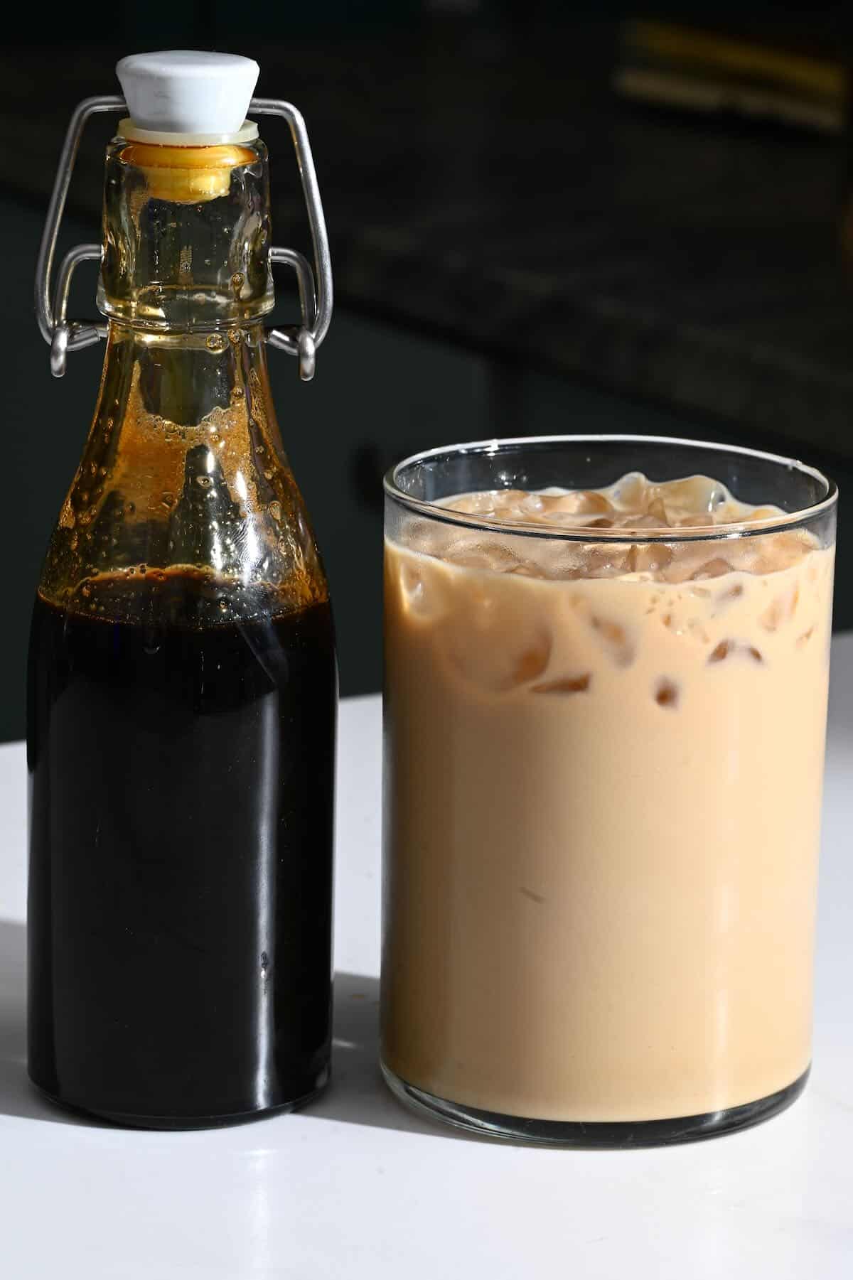 Cafe latte in a glass and coffee syrup in a bottle