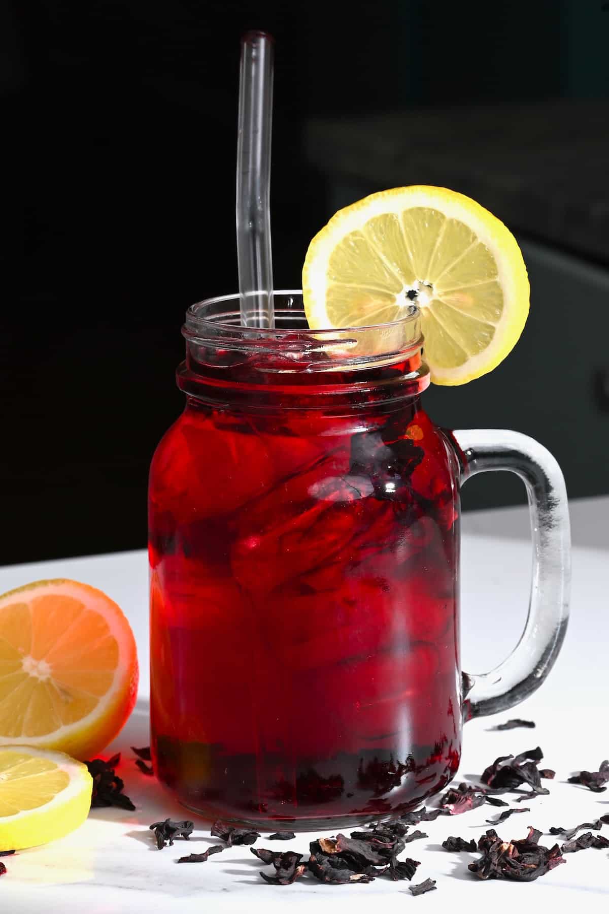 A mason jar with red tea and a lemon slice