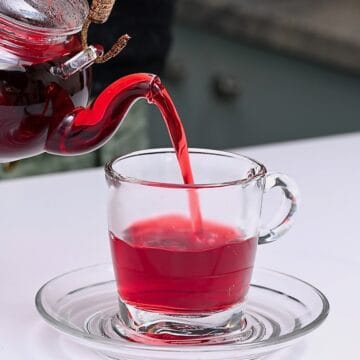Pouring hibiscus tea in a glass cup