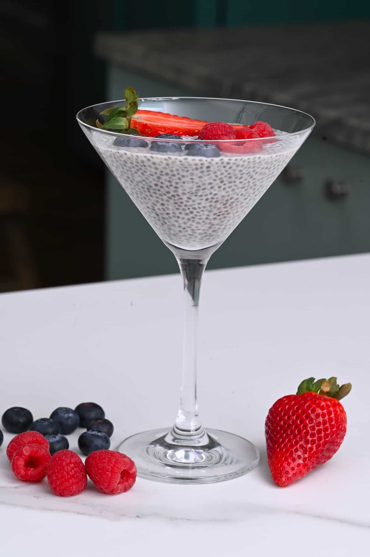 A glass with chia pudding topped with berries