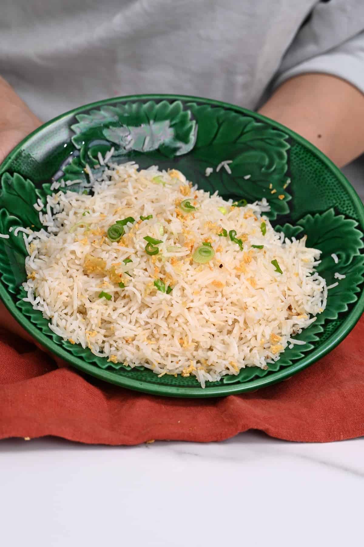 Garlic rice topped with green onion in a bowl