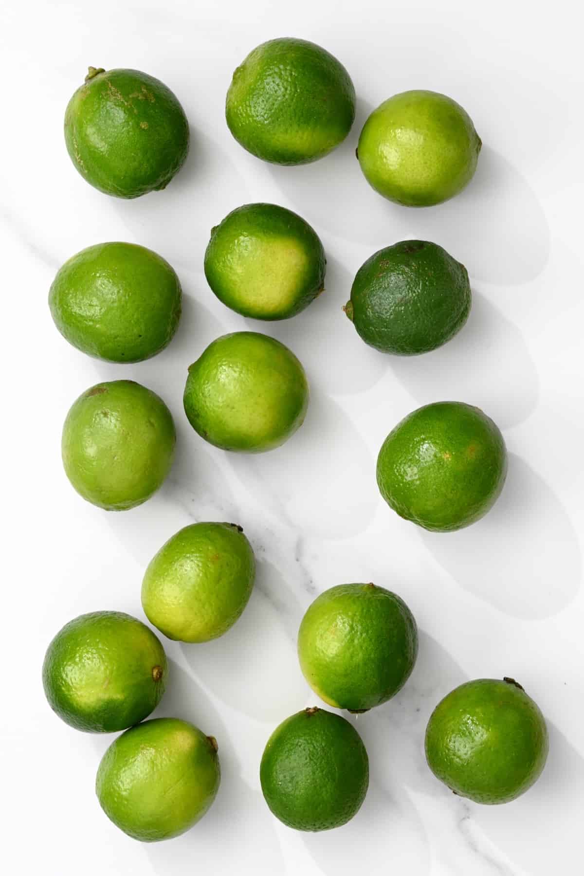 Fifteen limes on a flat surface