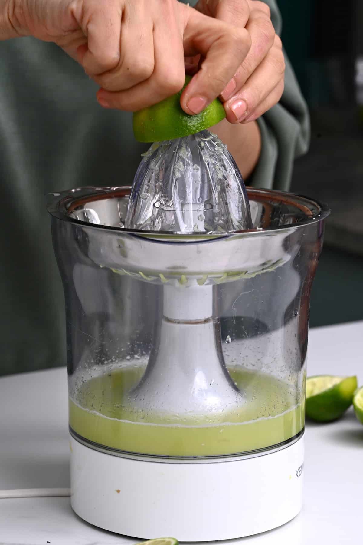Juicing a lime on a citrus juicer