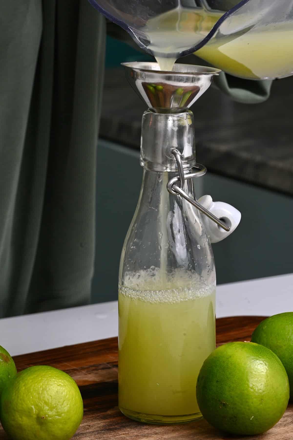 Pouring freshly squeezed lime juice in a bottle