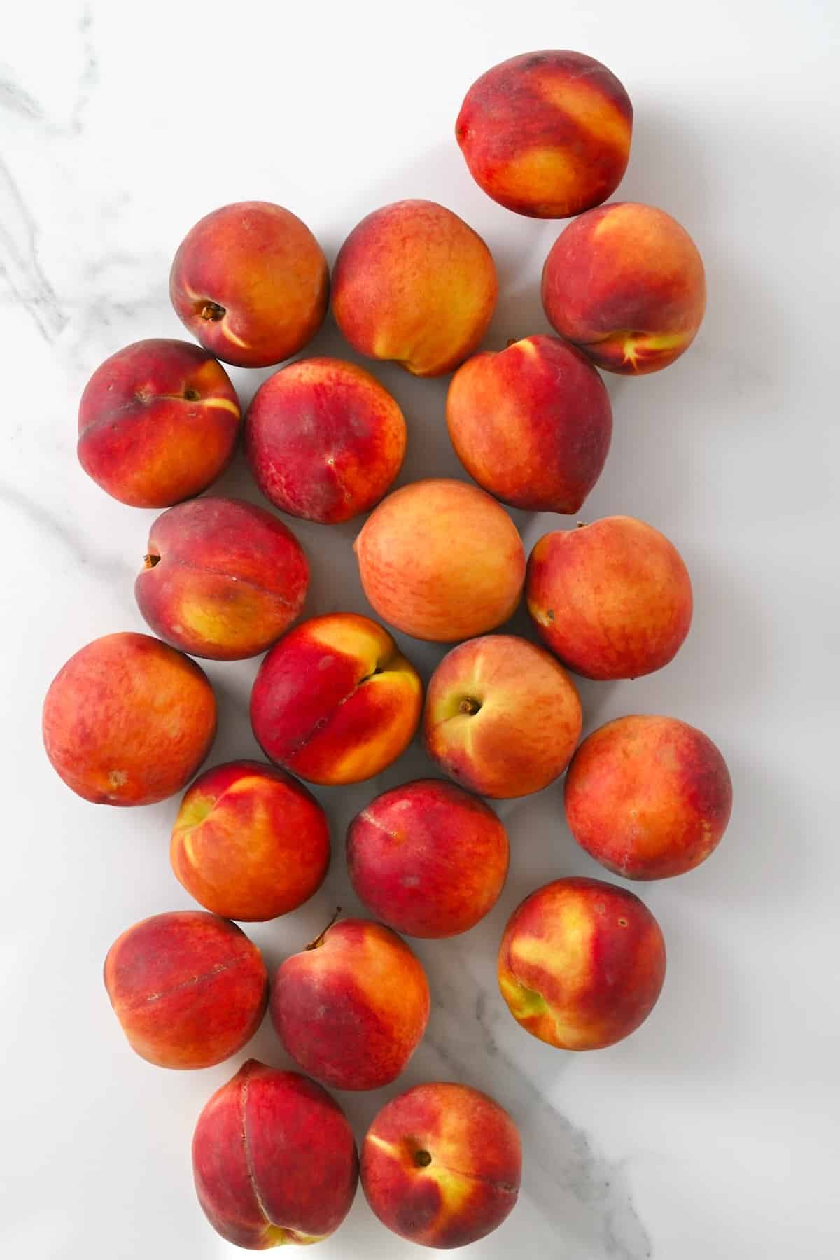 Lots of peaches on a flat surface