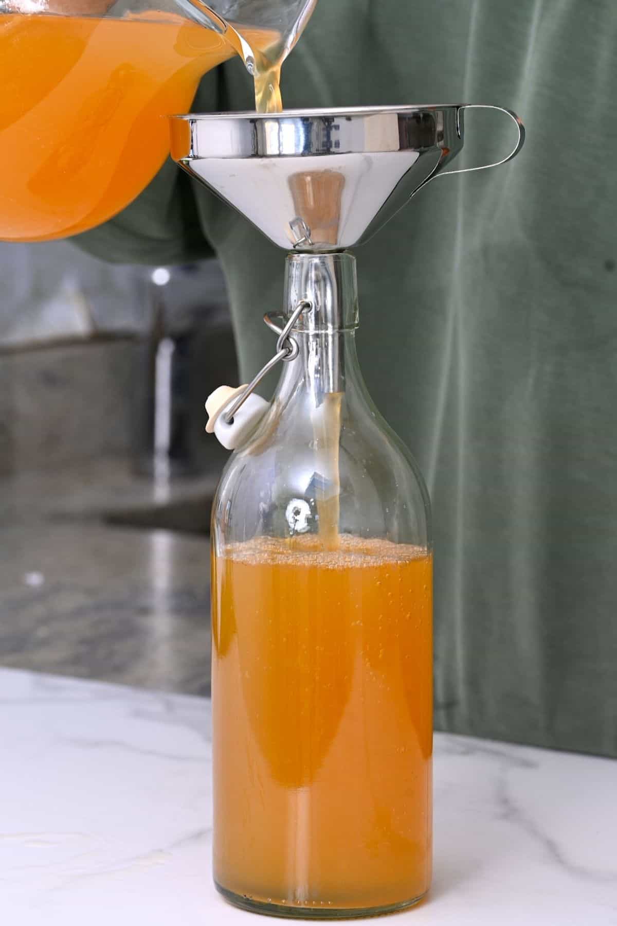 Pouring tepache in a bottle