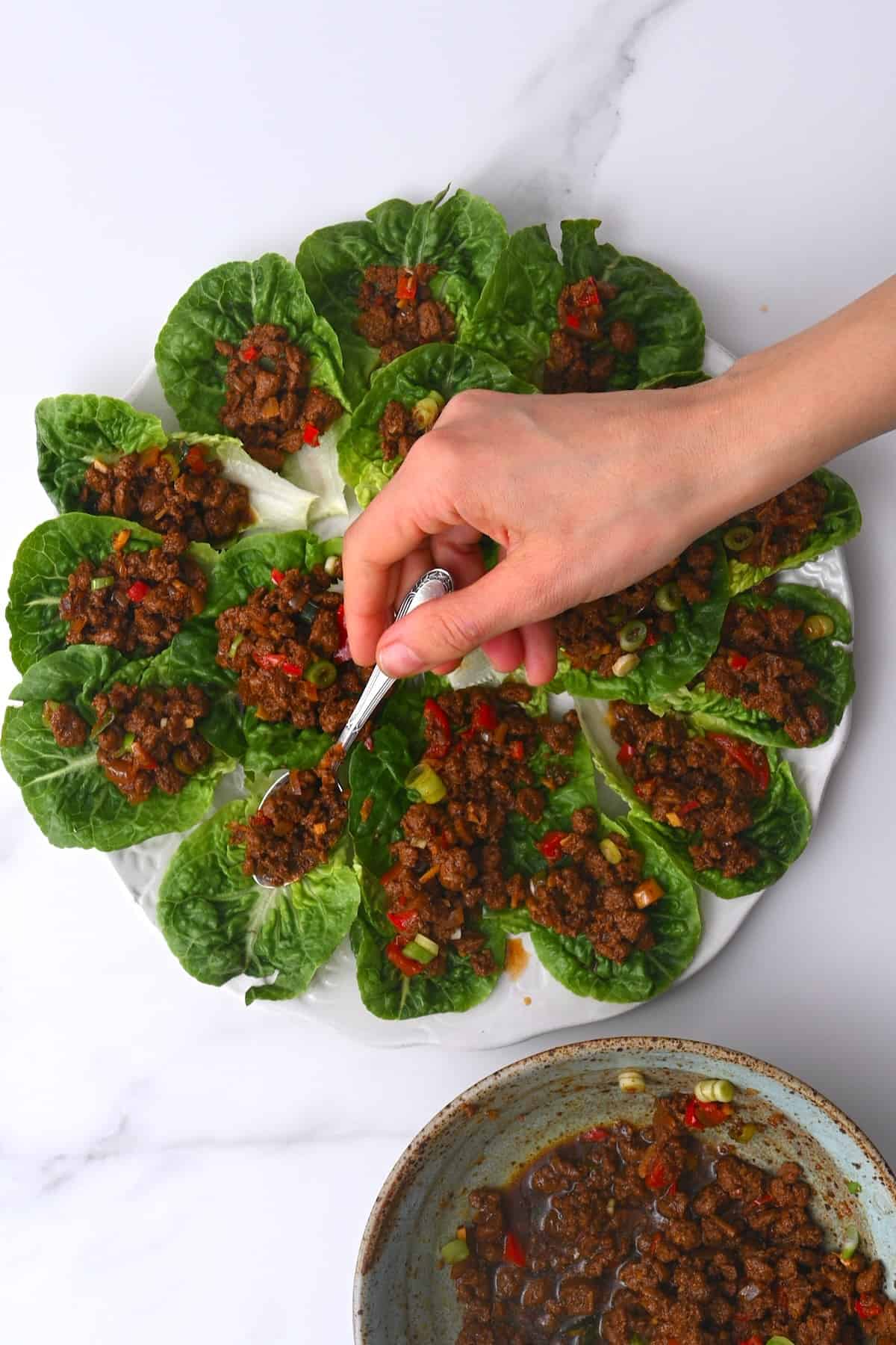 Assembling lettuce wraps on a plate