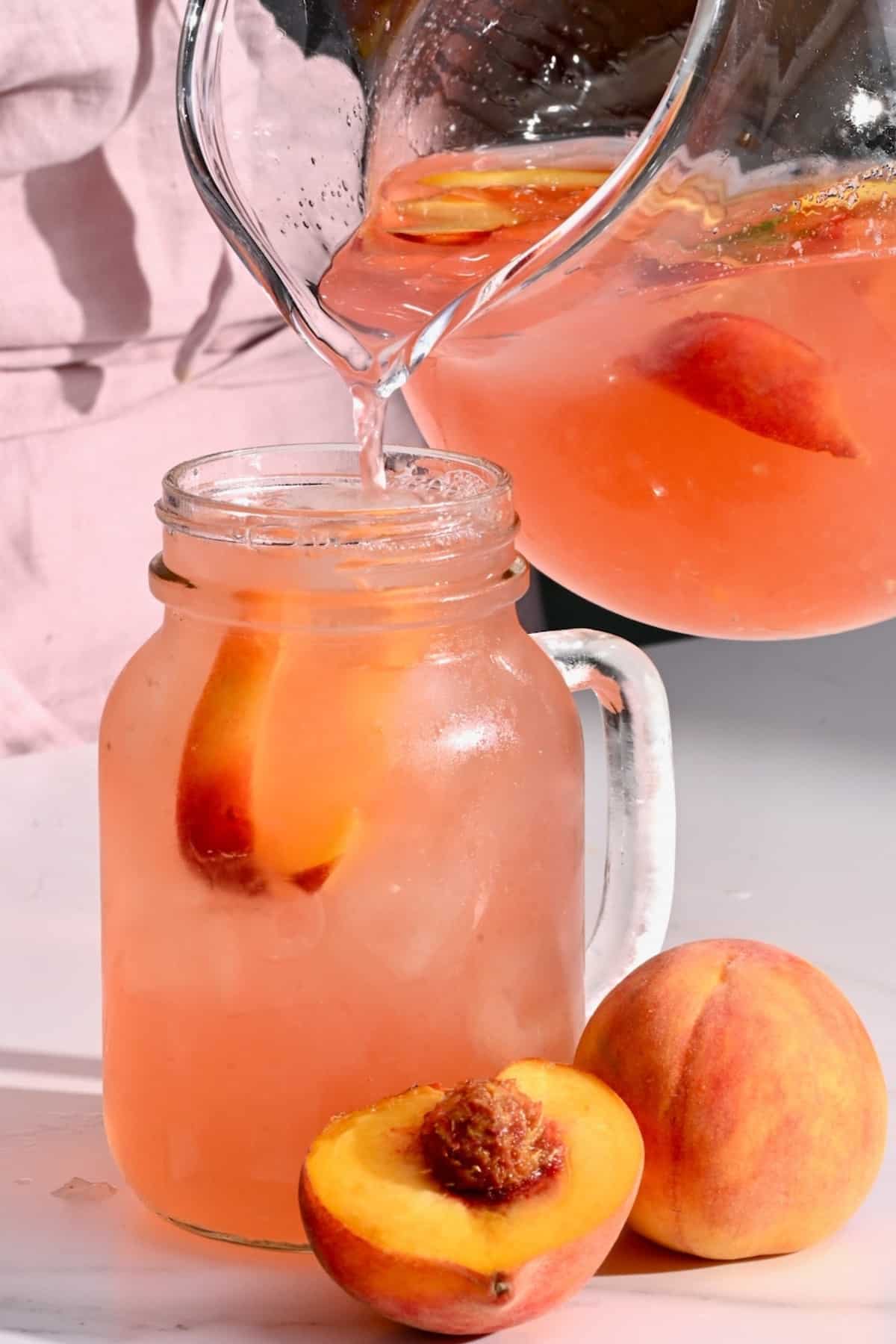 Pouring peach lemonade into a glass