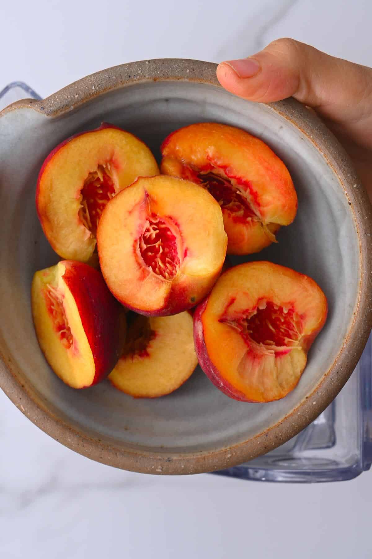A bowl with halved peaches