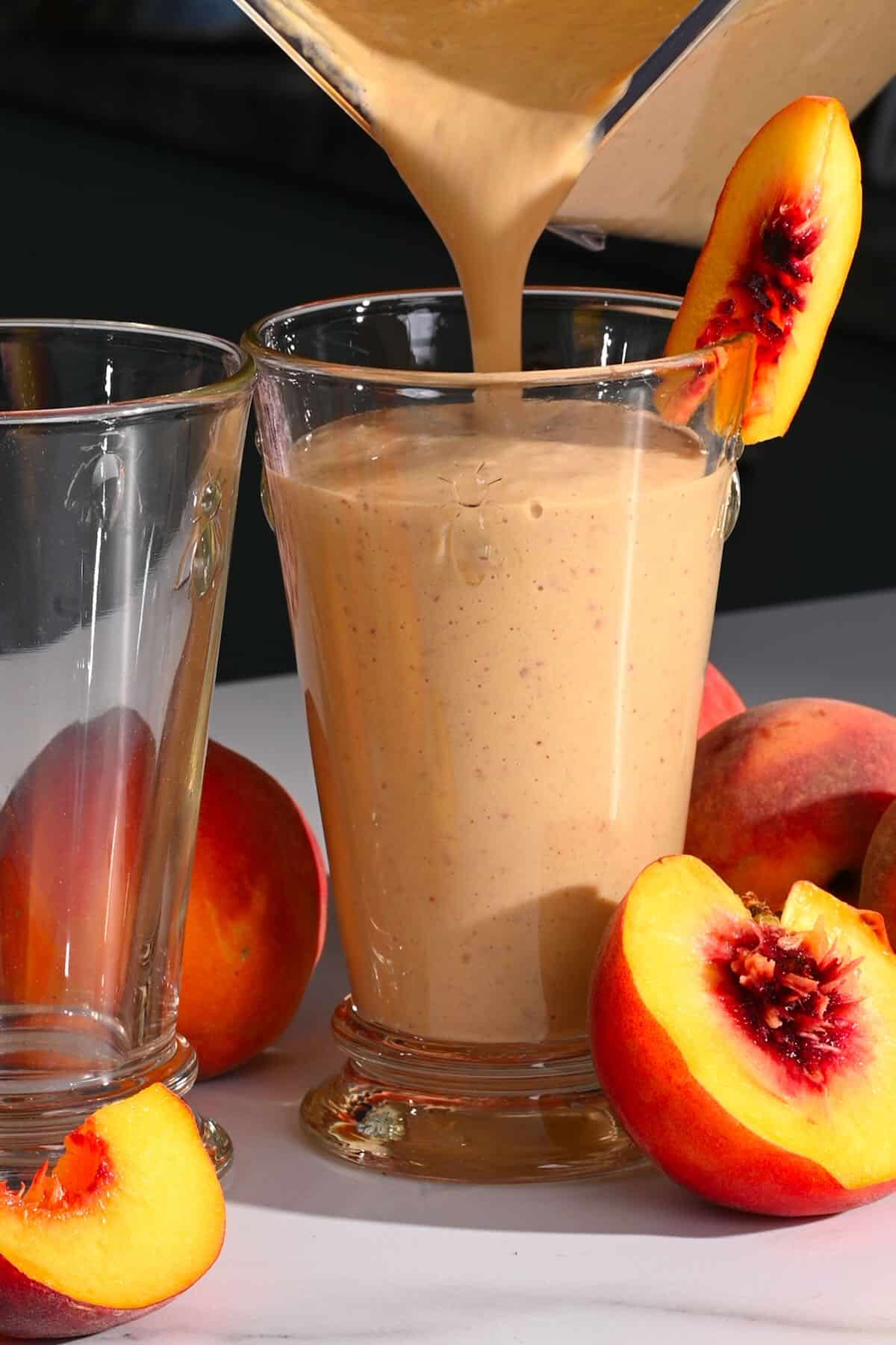 Pouring peach smoothie in a glass