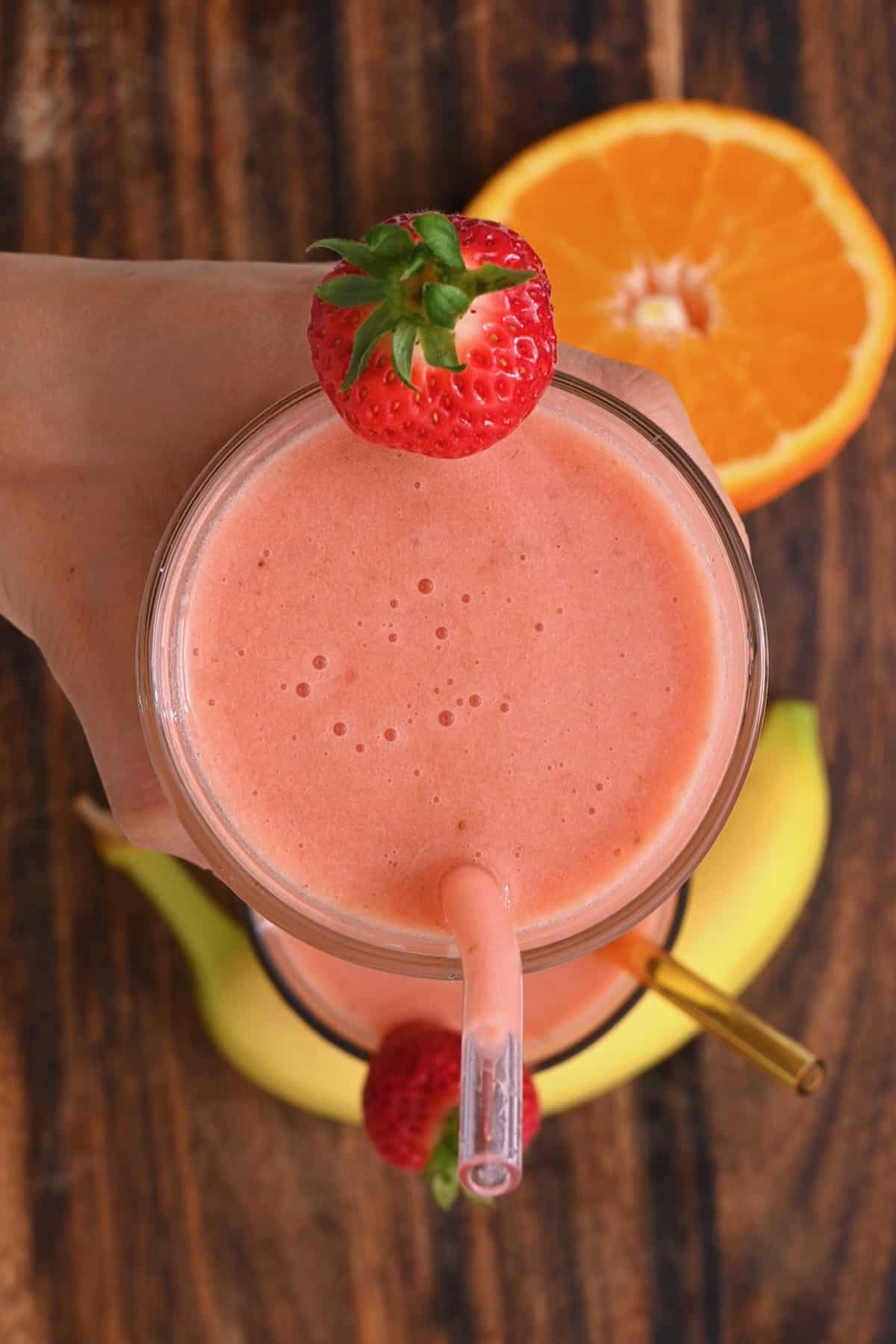 Top view of a glass with smoothie topped with a strawberry