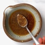 A spoonful of asian salad dressing over a bowl - 14