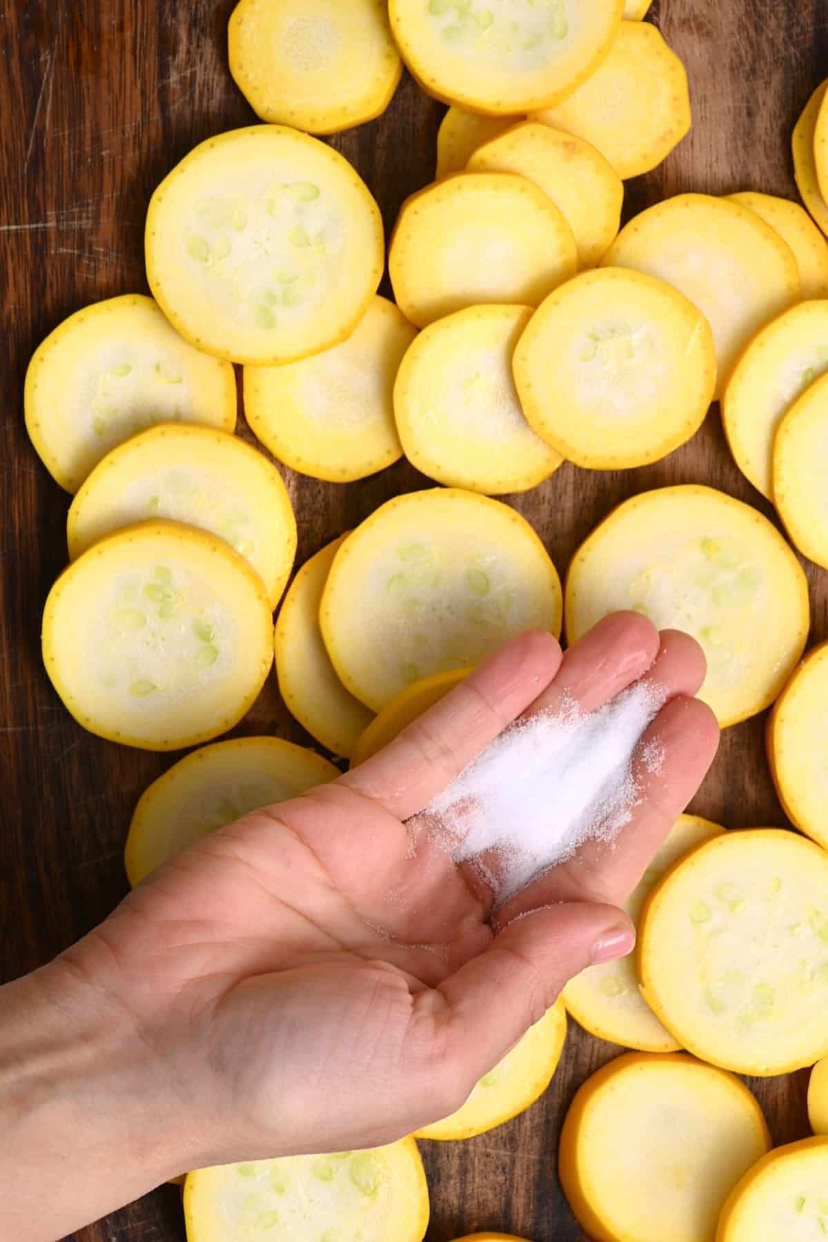 Salting slices of yellow squash