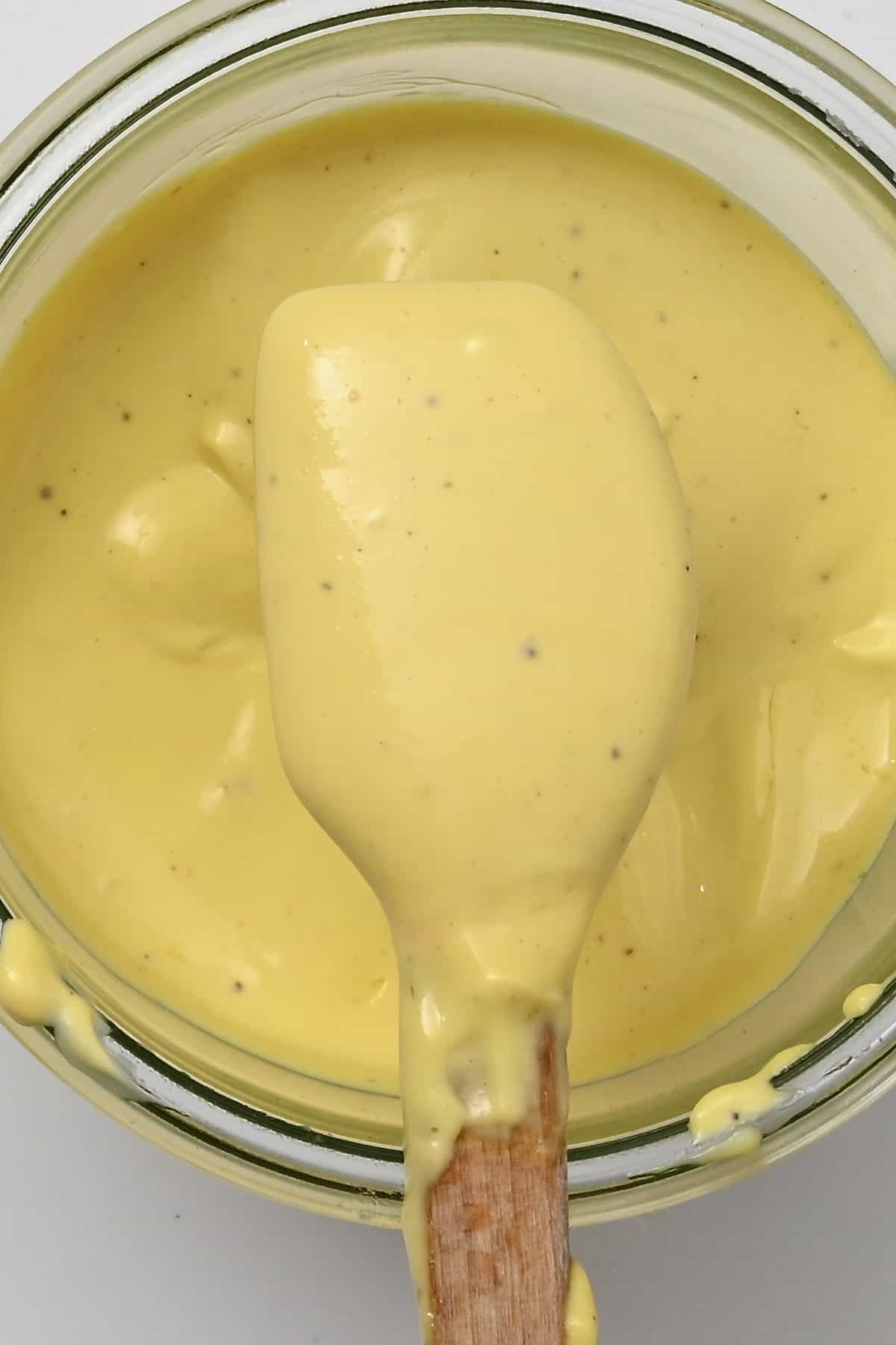 A spoonful of garlic mayo over a jar full with it