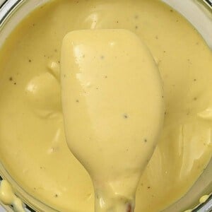 A spoonful of garlic mayo over a jar full with it
