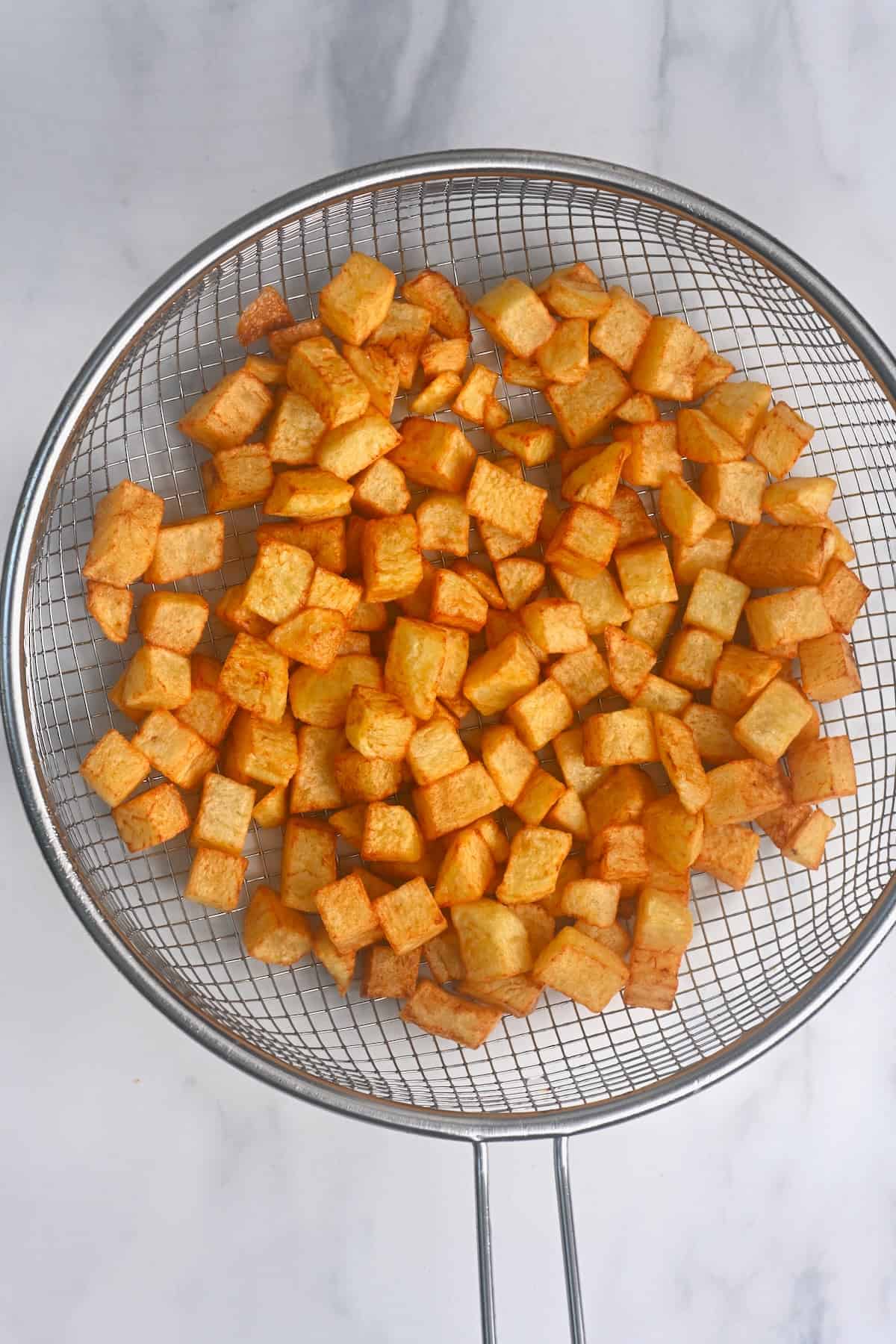 Deep fried potatoes in a sieve