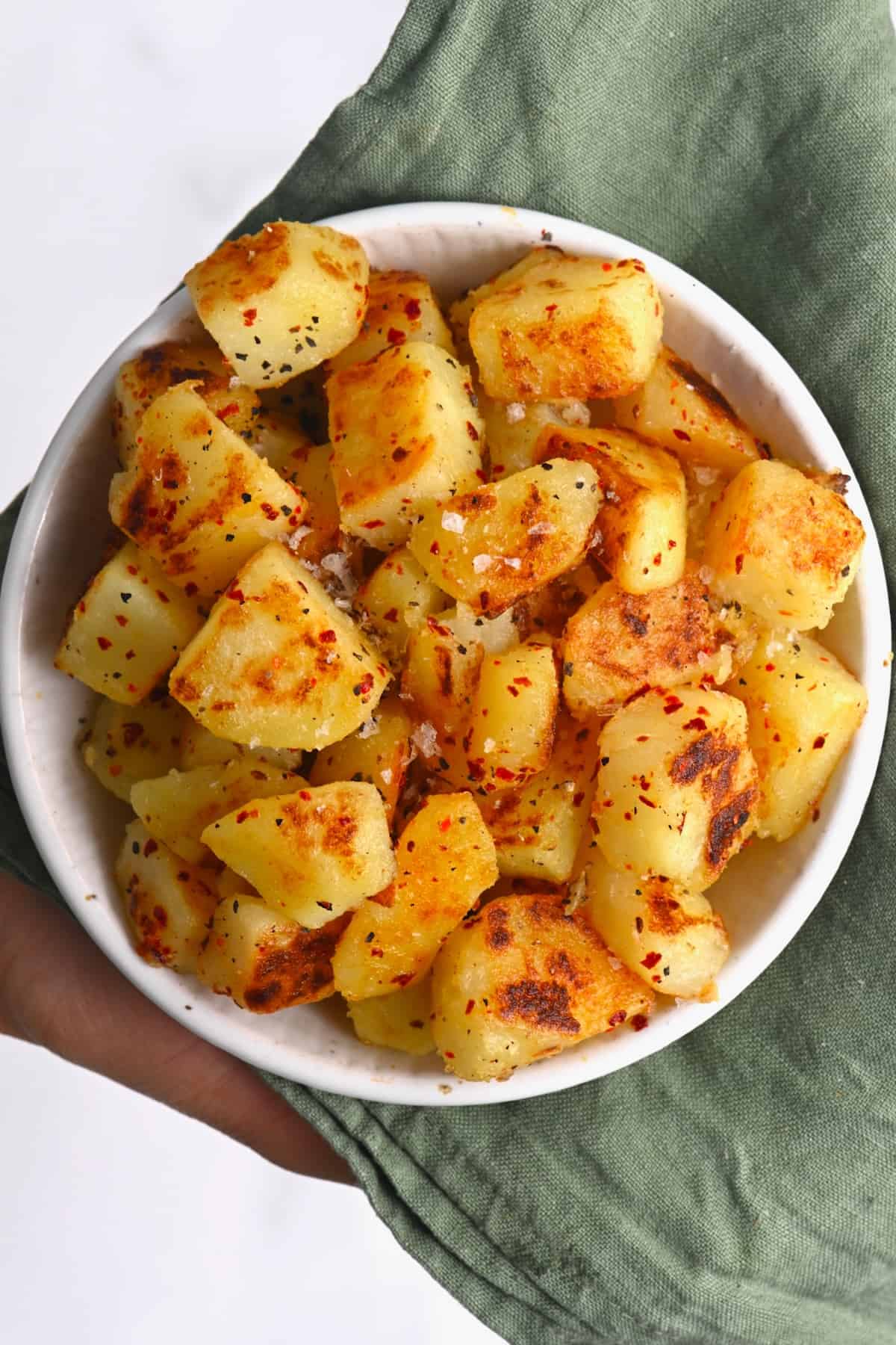 Home fries topped with salt and paprika in a bowl