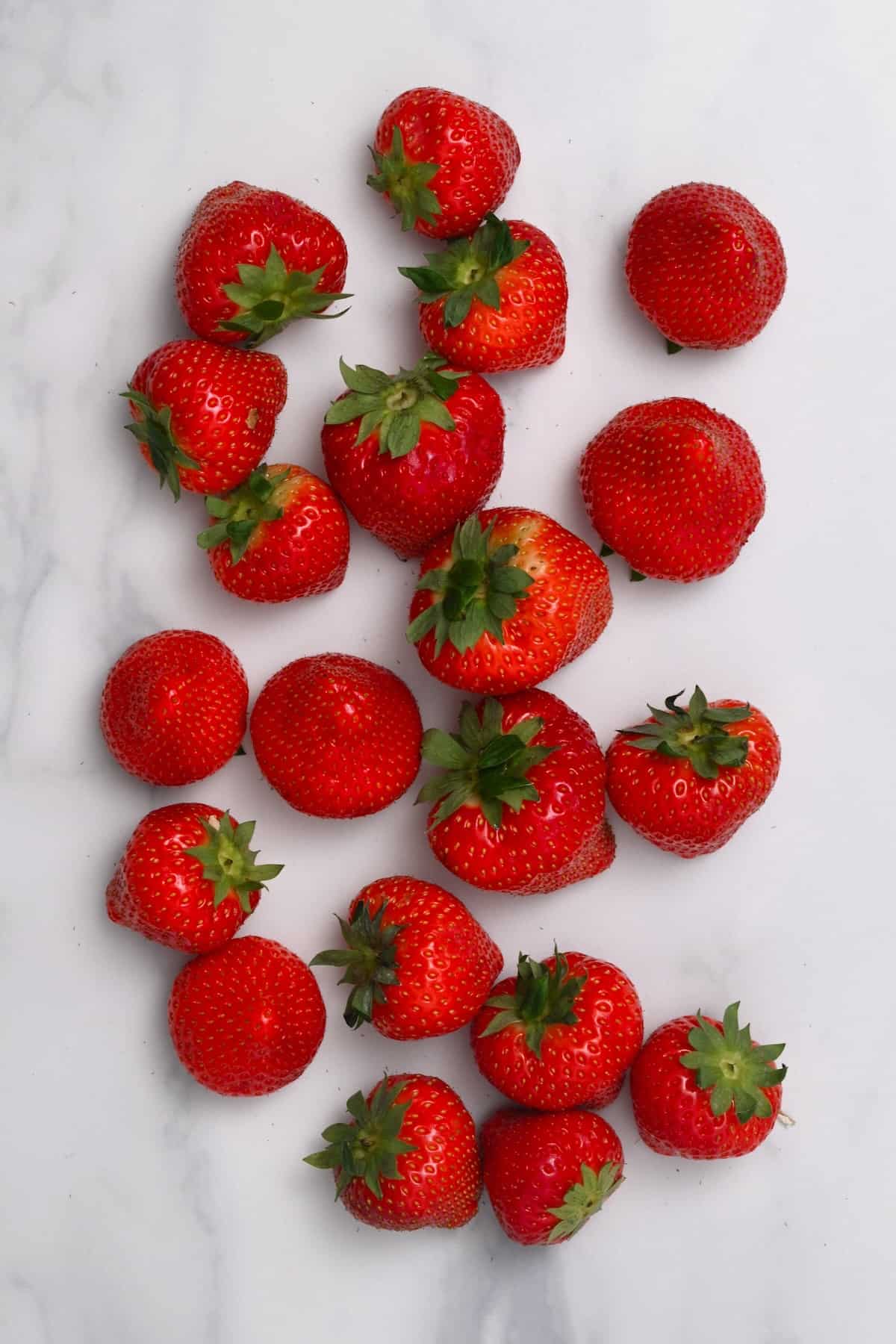 A bunch of strawberries on a flat surface