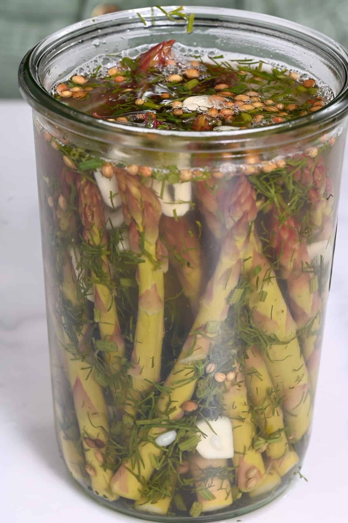 Jar filled with brine and asparagus