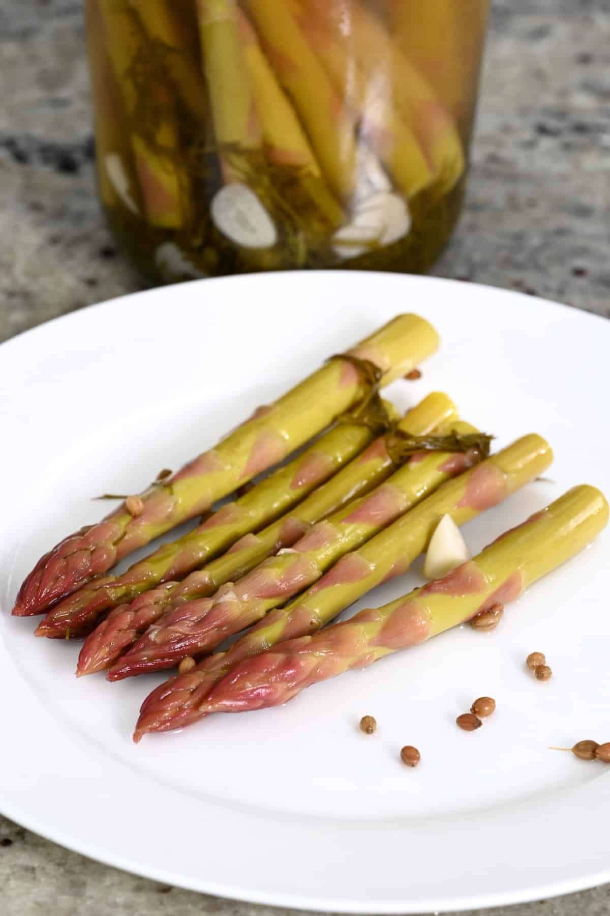Six homemade asparagus pickles on a plate