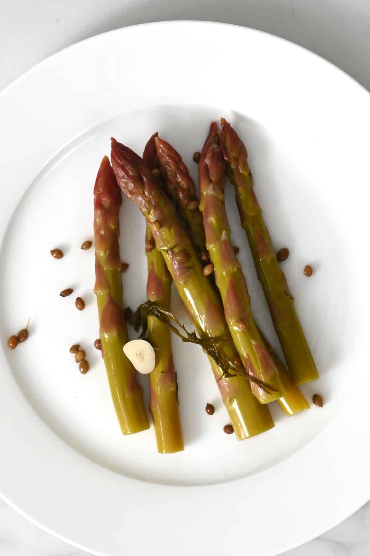Six asparagus pickles on a plate