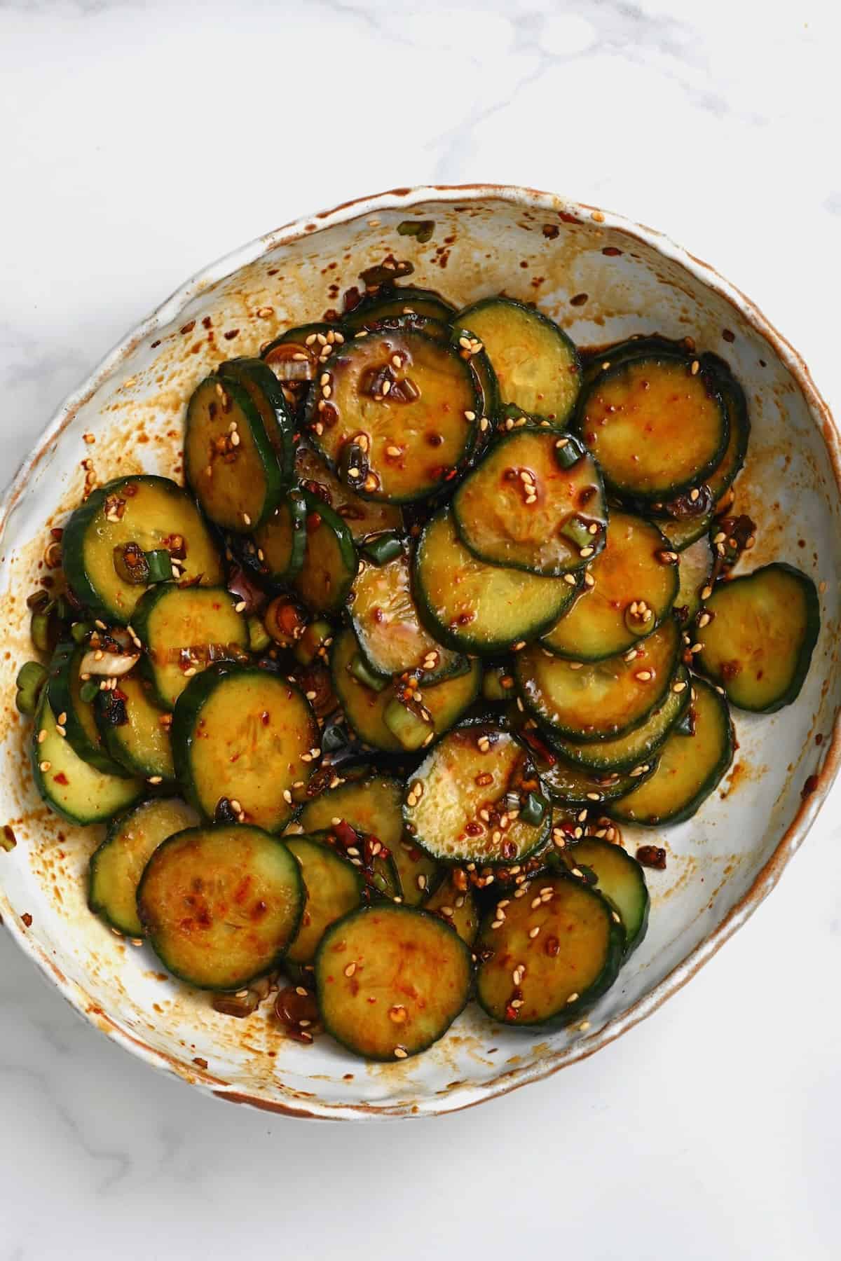 A bowl with crunchy Asian cucumber salad topped with sesame seeds