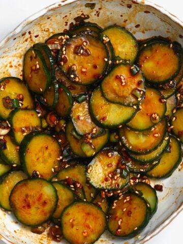 A bowl with crunchy Asian cucumber salad topped with sesame seeds