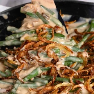A spoonful of green bean casserole topped with crunchy onions