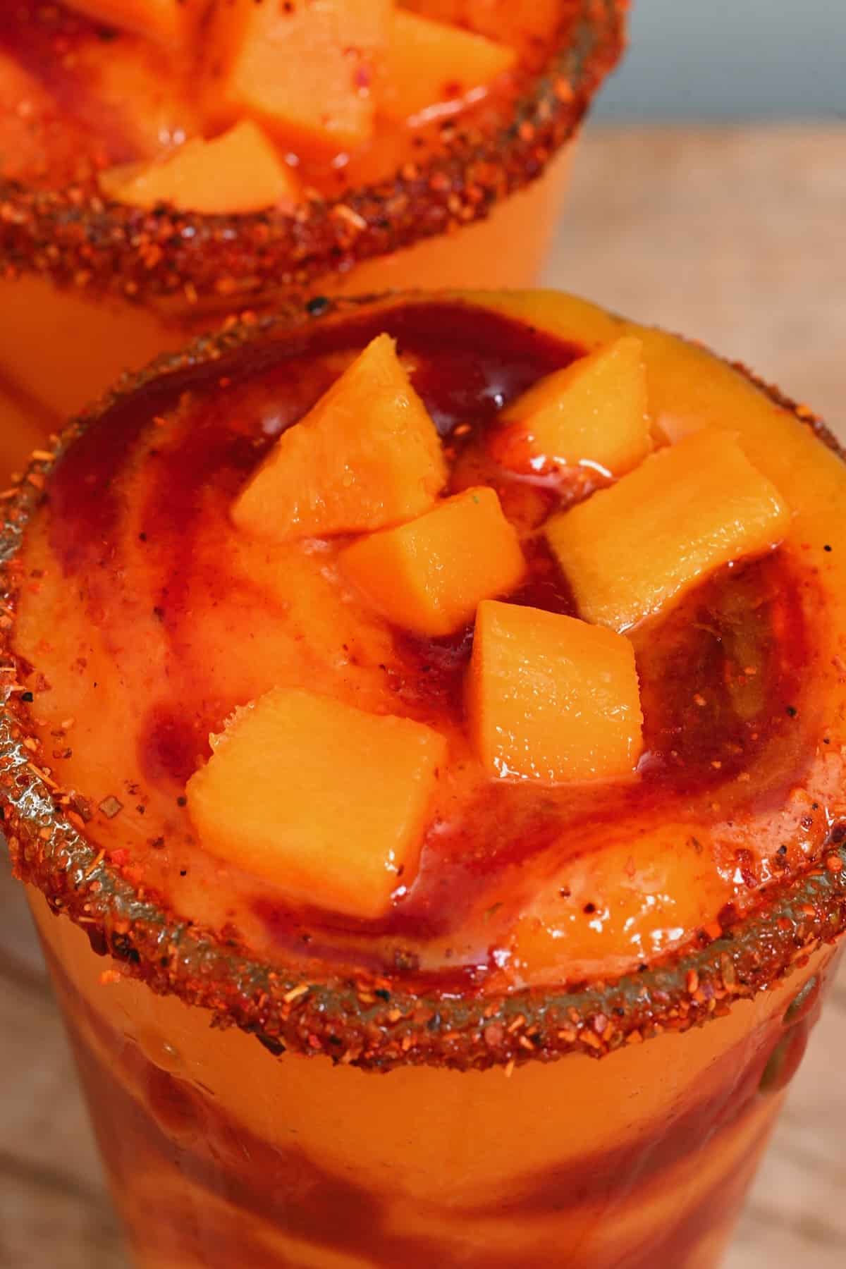 Close up of mangonada topped with mango