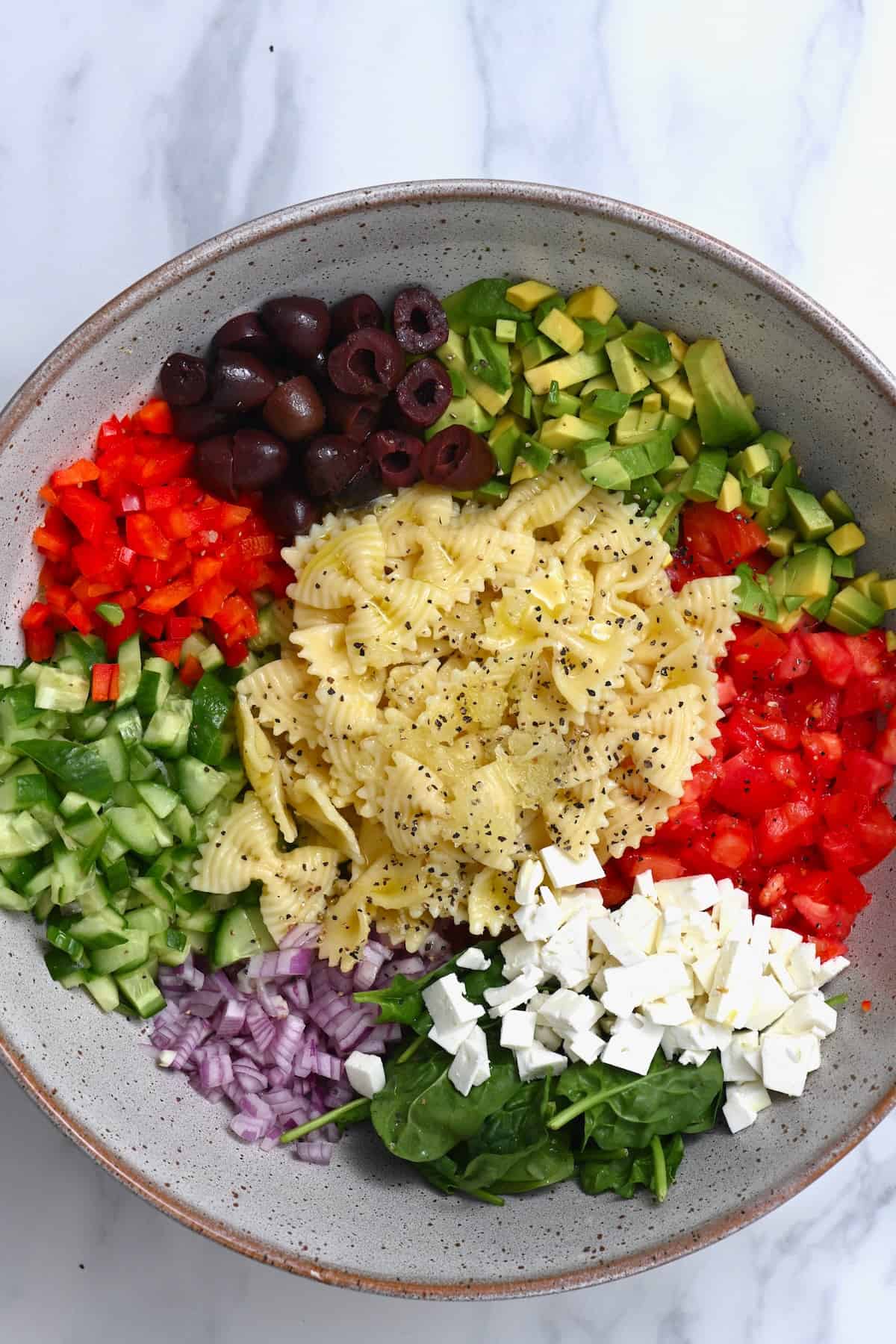 A bowl with ingredients for pasta salad