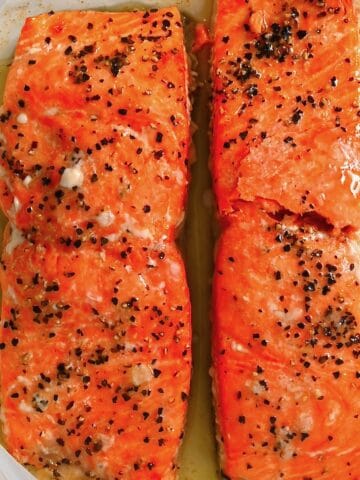 Two cooked salmon fillets over parchment paper